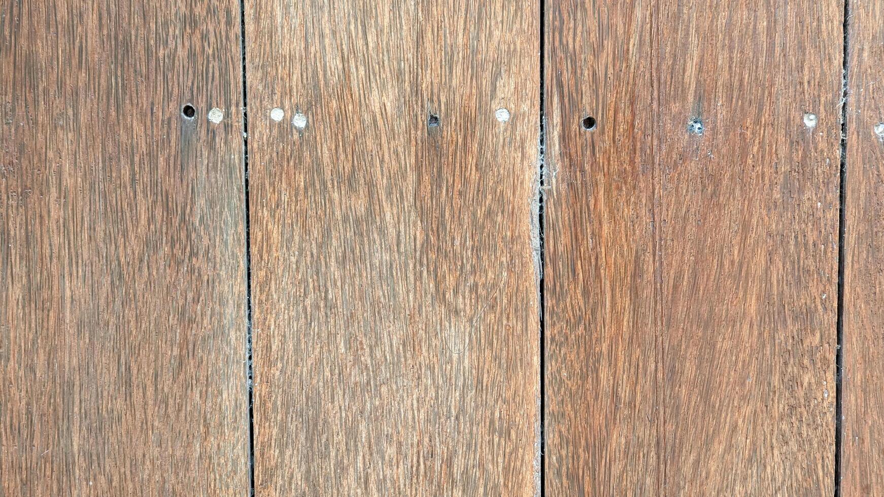 wood texture with natural grains and screw holes. The aged wooden planks feature a rustic appearance, perfect for backgrounds, construction projects photo