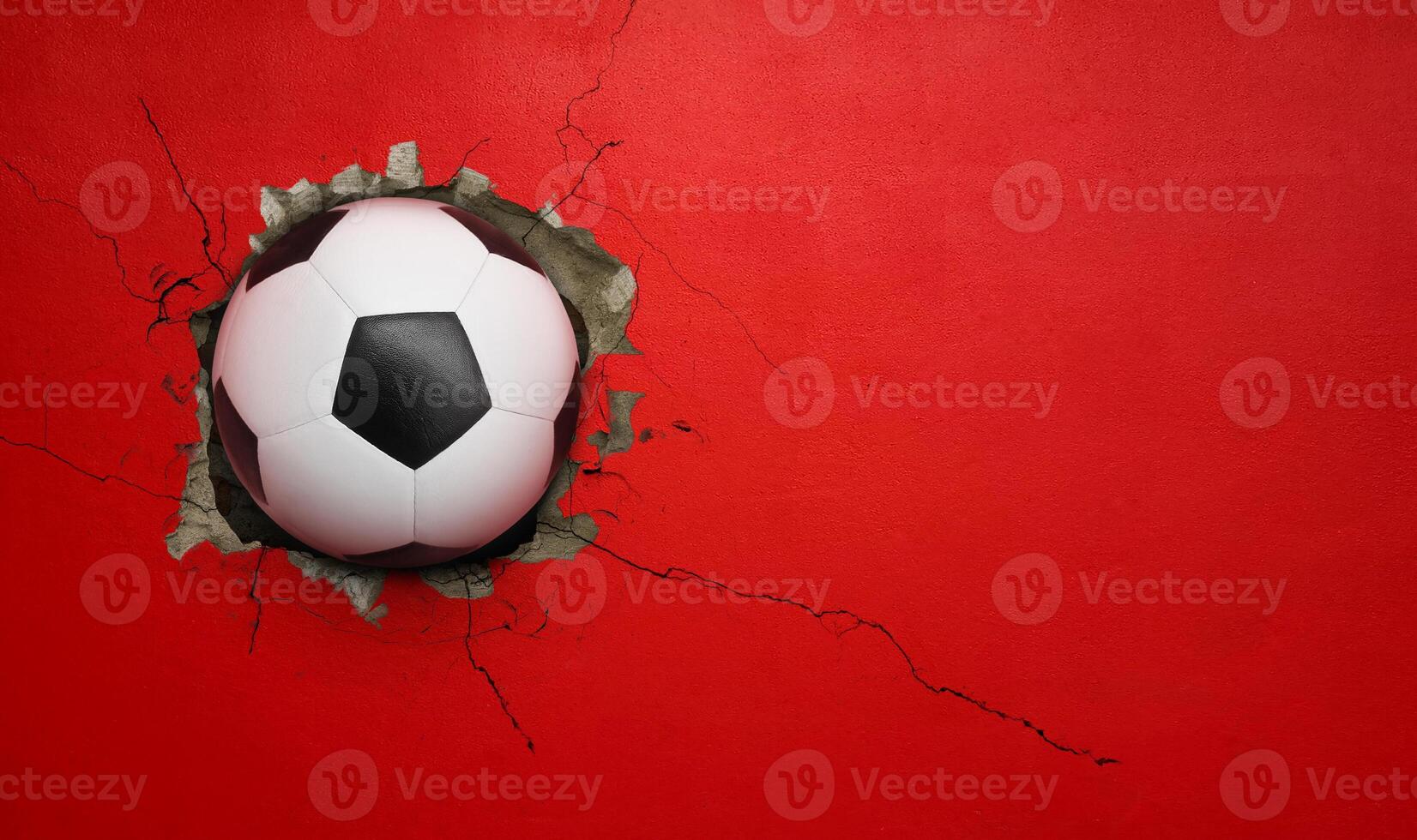 Soccer ball breaks through red concrete wall, concept of power, strength. photo