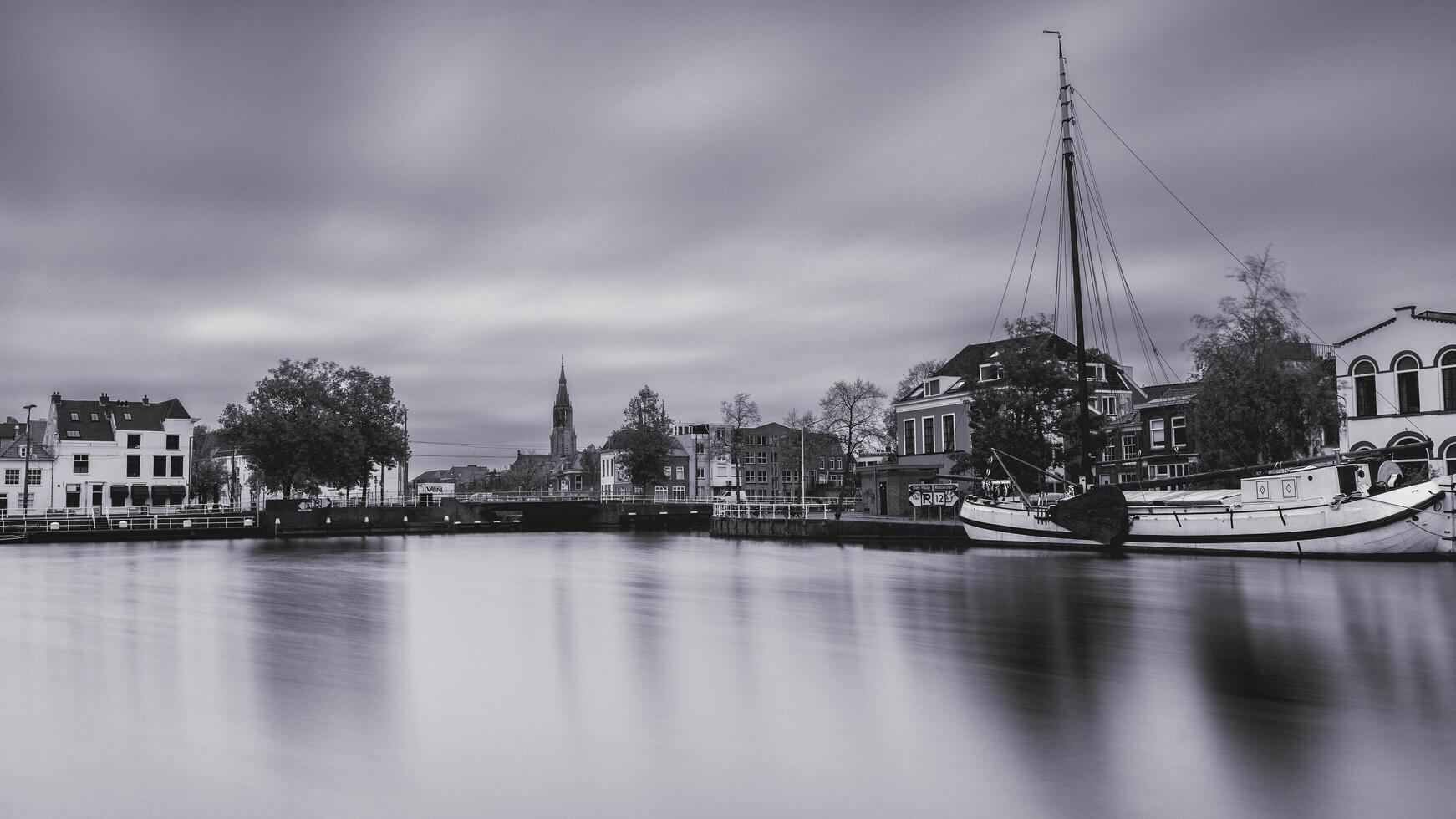 Delft, The Netherlands October 15, 2024. The harbour of Delft, with some old boats, and the skyline from the city. photo