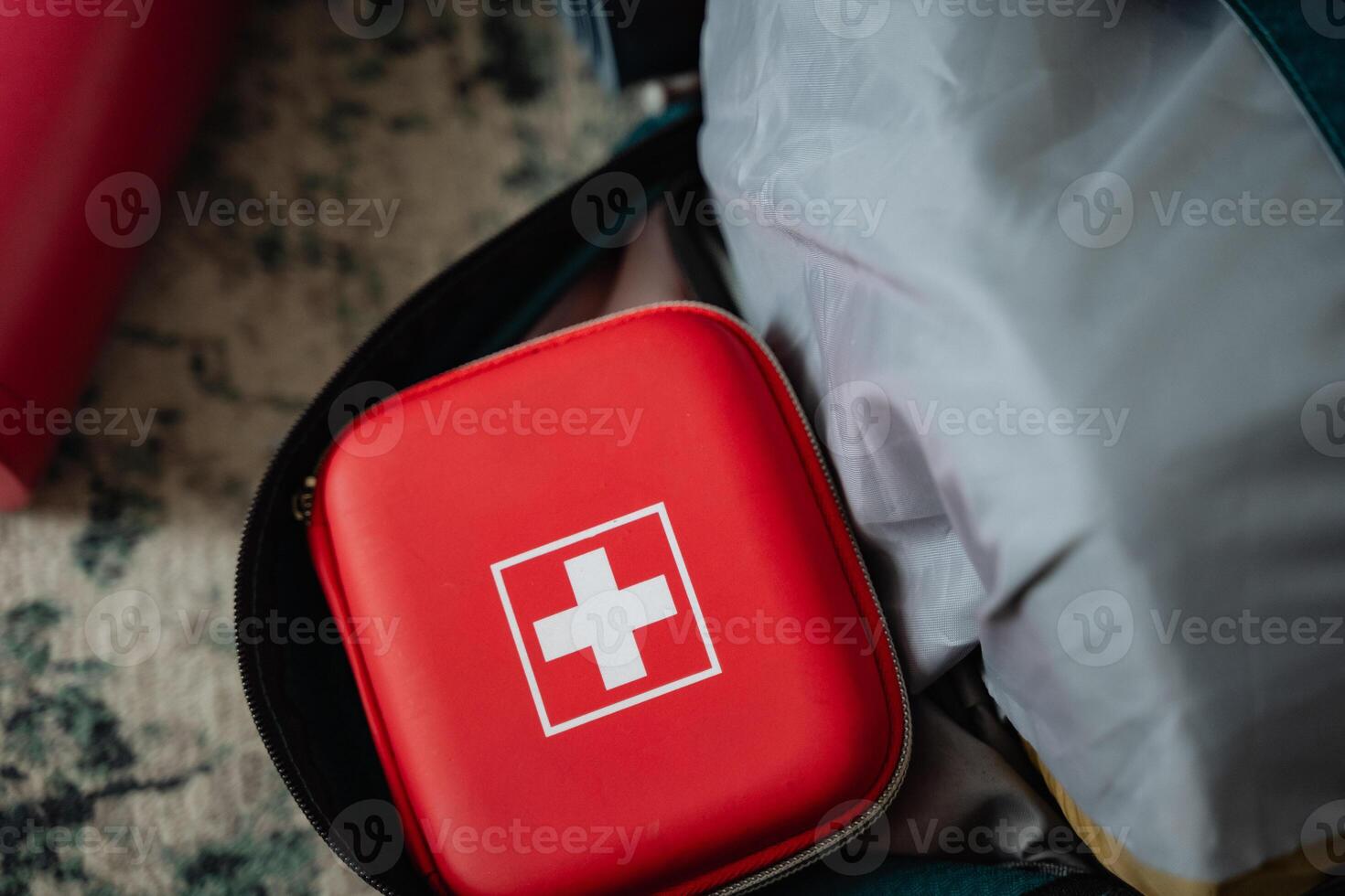 A bright red first aid kit is securely placed inside of a sturdy backpack, ready for any emergency situations that may arise during your outdoor adventures or daily activities photo