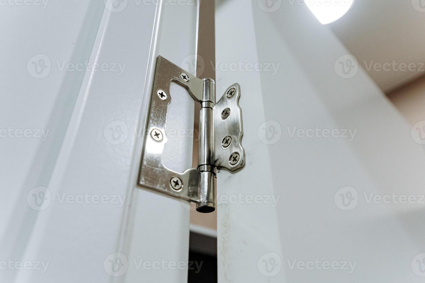 This image showcases a detailed close up view of a door hinge positioned on a pristine white door, highlighting the intricate design and functionality of this essential household hardware photo