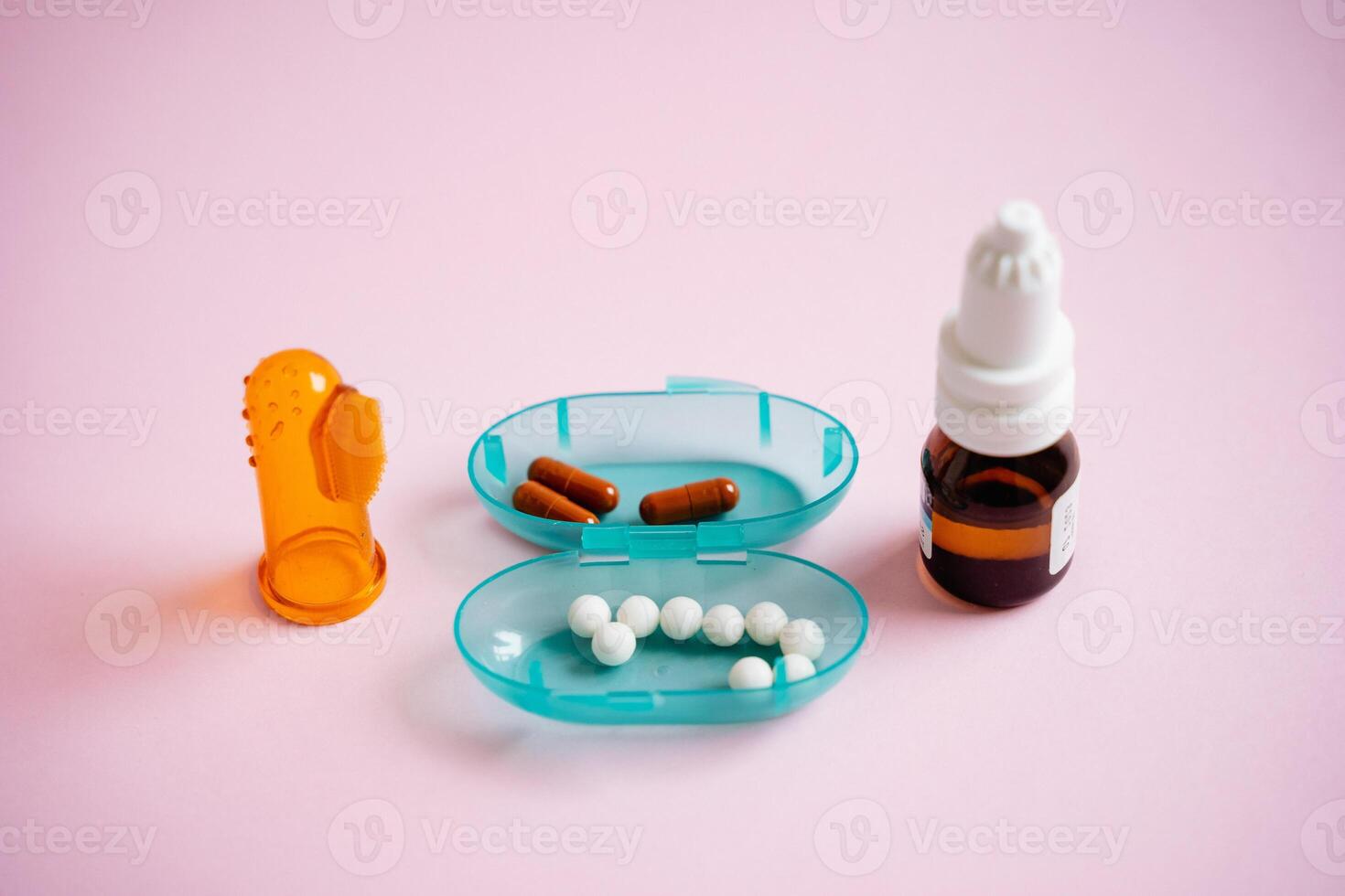 A vibrant blue container that is filled to the brim with various pills, alongside a bottle of liquid drops, all positioned on a striking pink surface, creating a visually appealing scene photo