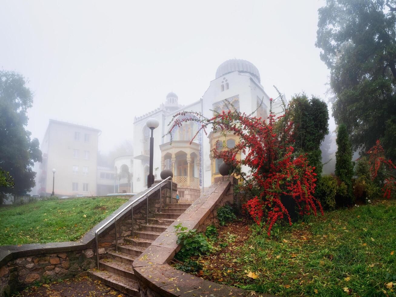 Zheleznovodsk, Russia - October, 2022 The palace of the Emir of Bukhara in a foggy morning park. Beautiful wet and foggy embankment. Foggy rainy autumn landscape. photo