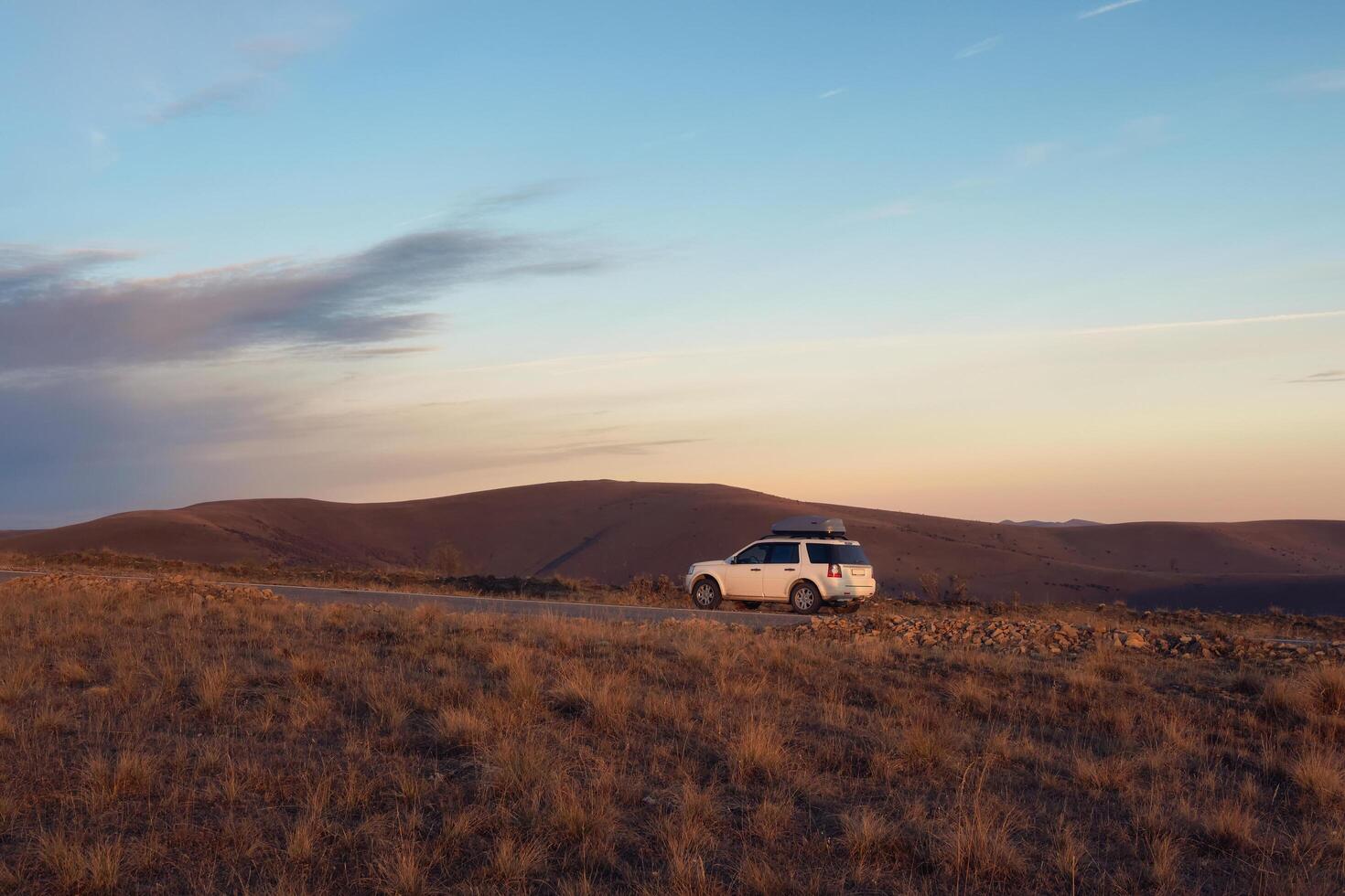 Russia. Karachay-Cherkessia, Shajatmaz plateau. October 2022 White car suv parked near scenic route road in autumn Caucasus l photo