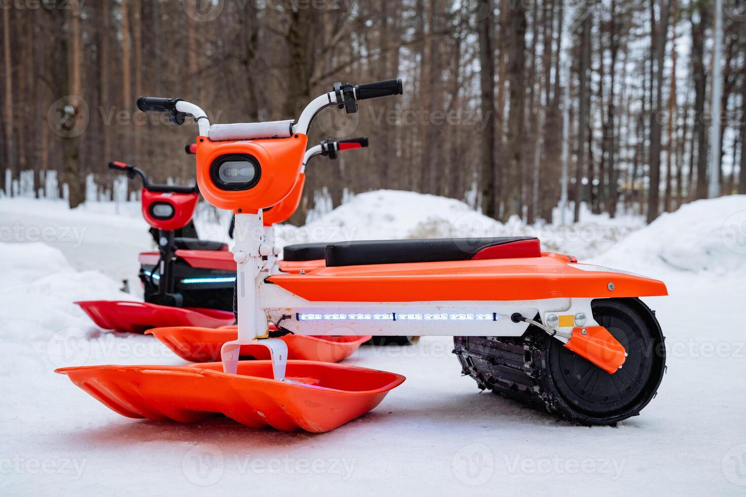 A picturesque row of snowmobiles lies parked amidst the serene, white expanse of the snowcovered ground, creating a beautiful winter scene that embodies the essence of the season photo