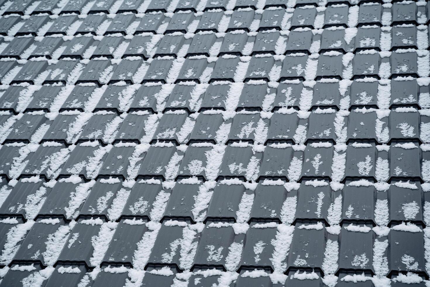 This closeup image showcases a rooftop blanketed in sparkling snow, highlighting the captivating textures and intricate patterns of delicate snowflakes. The scene is mesmerizing photo