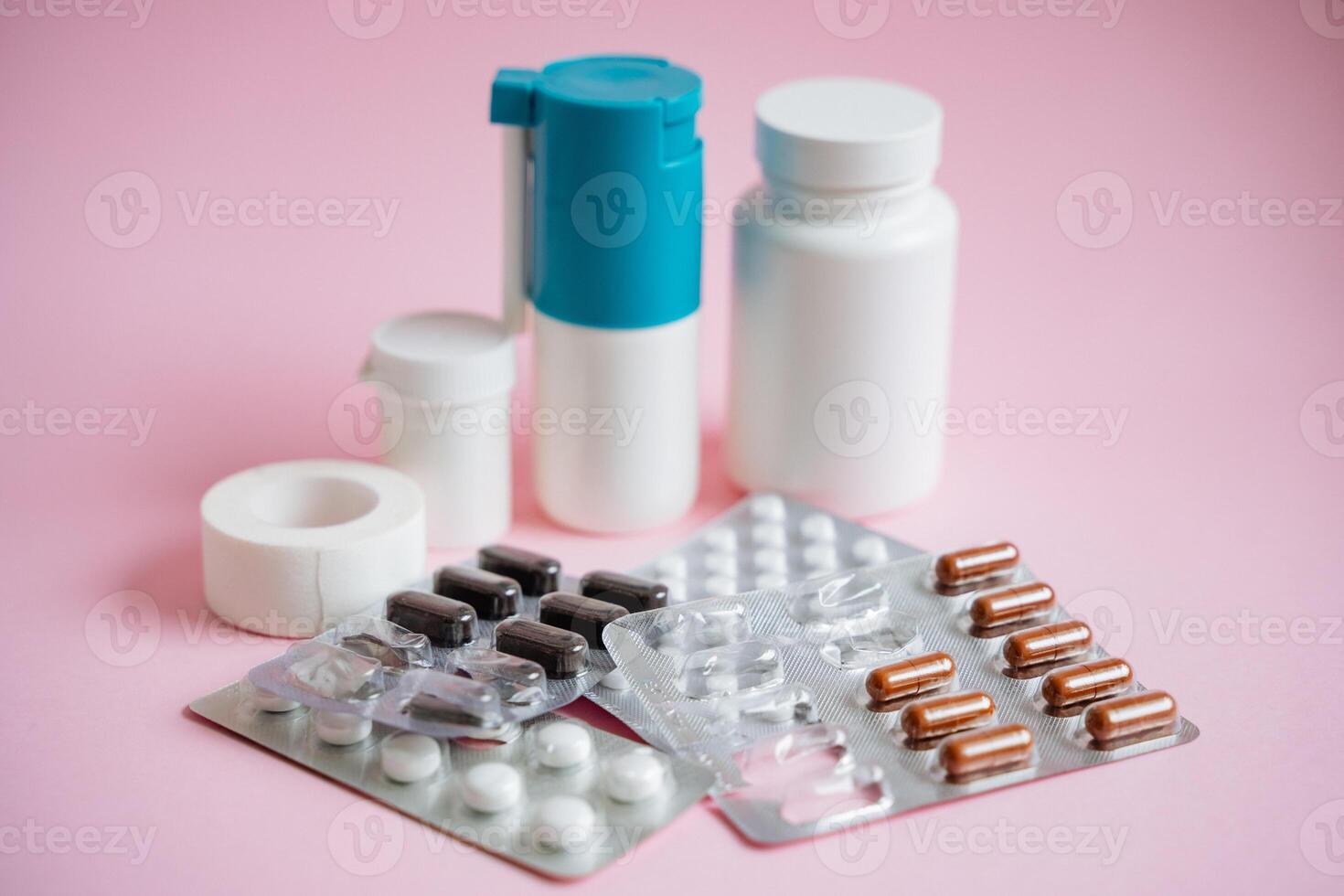A vibrant and colorful assortment of various pills and bottles is artistically arranged against a soft pink background, resulting in a visually appealing display of healthrelated items photo