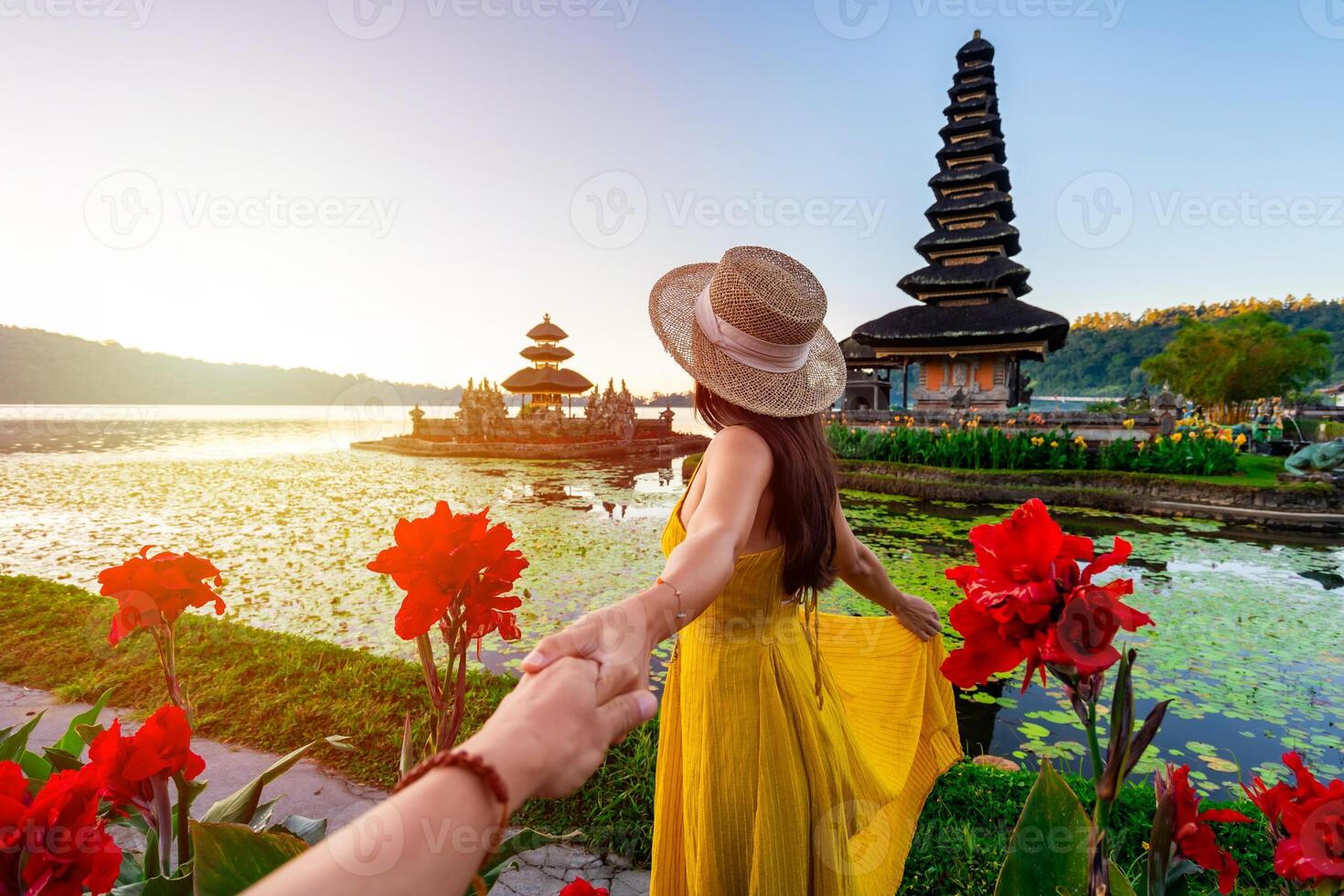 Young couple tourist enjoying the beautiful view at Ulun Danu Beratan temple in Bali, Indonesia photo