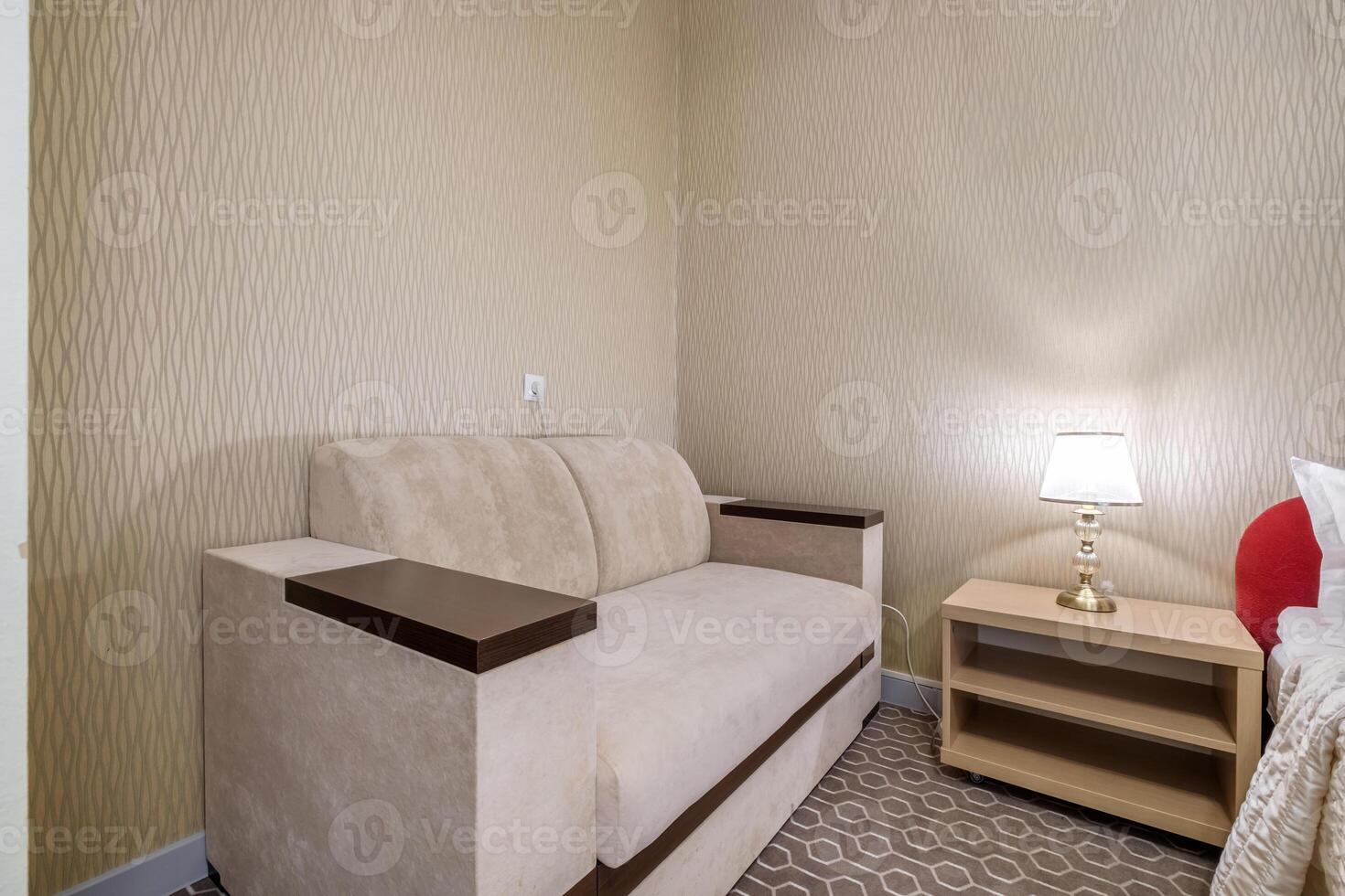 A small room with a couch and a lamp photo