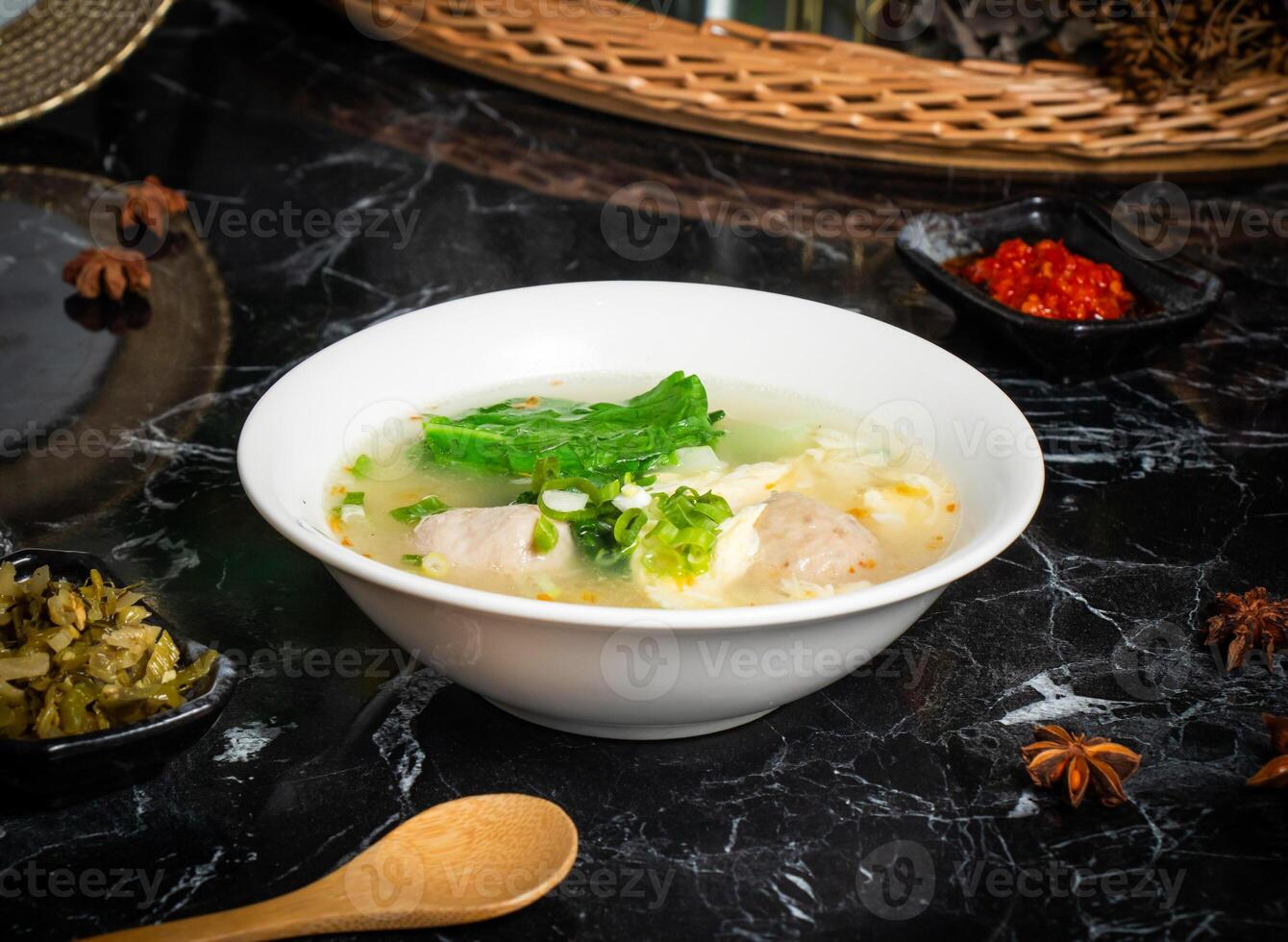 Taiwanese Mixed Soup with pork balls, vegetables and spoon served in bowl isolated on dark background side view of taiwan food photo