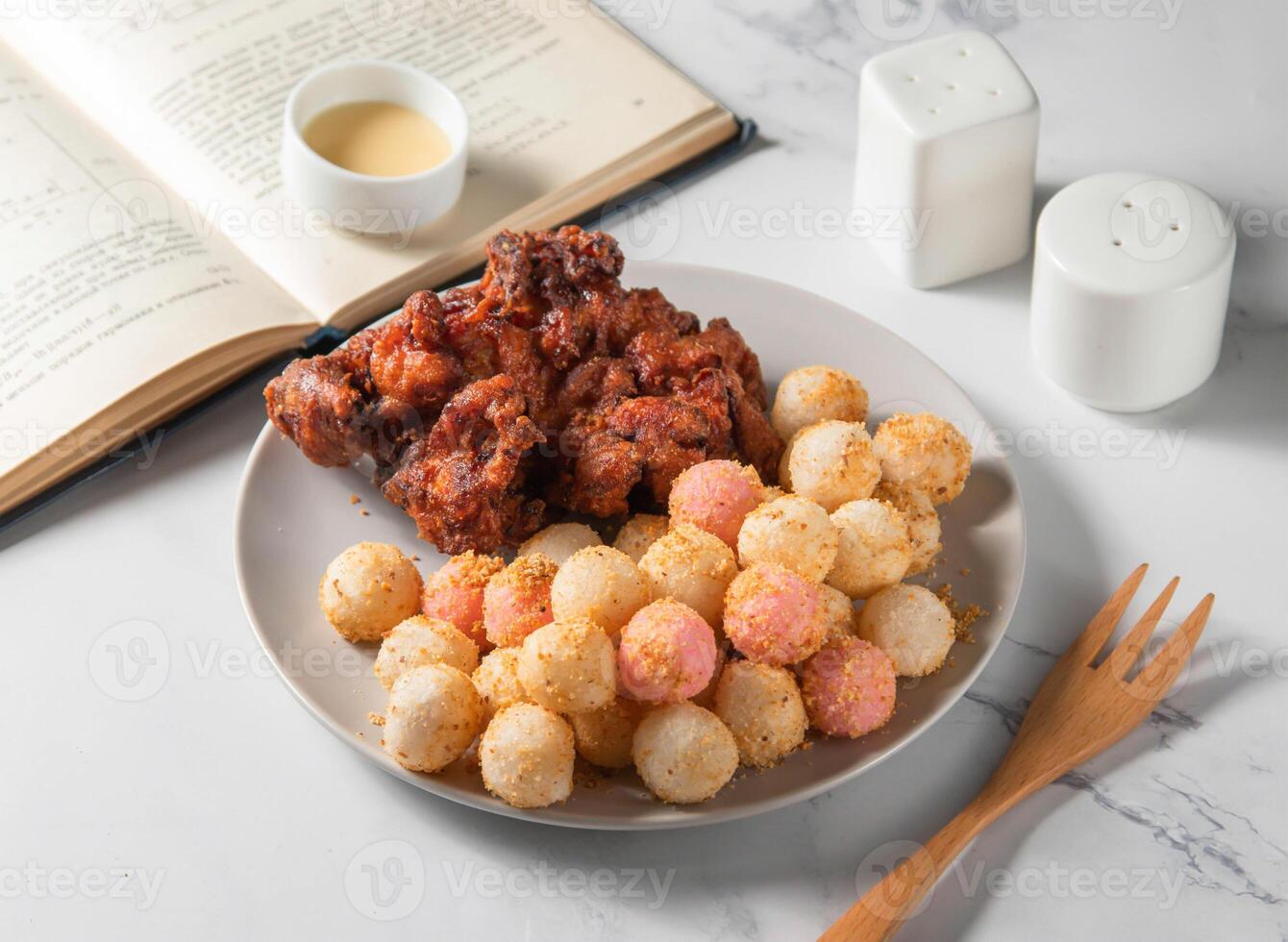 Fried Chicken thigh steak and fried rice balls with sauce served in plate with fork isolated on napkin side view of taiwan food photo