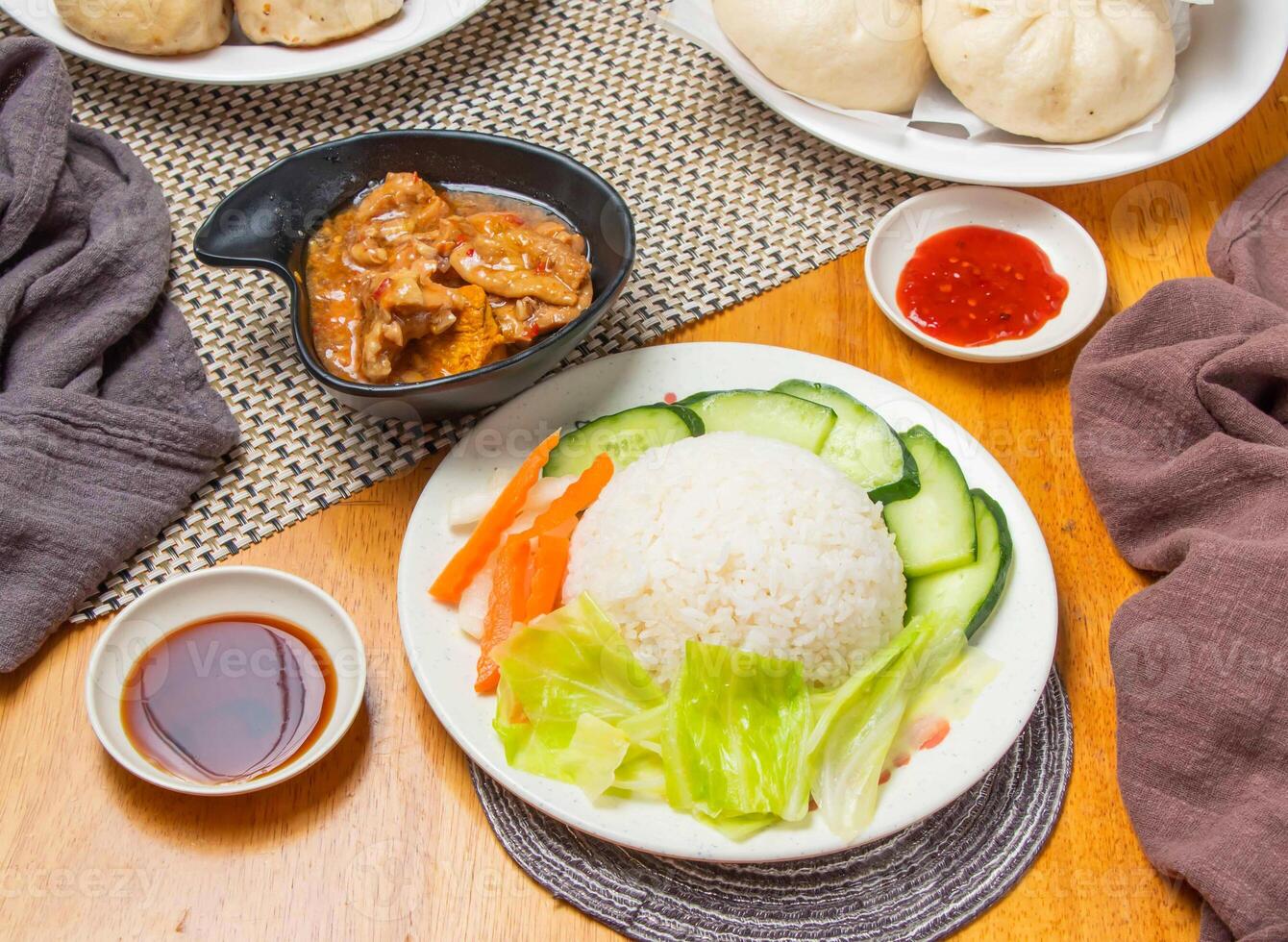 Lemongrass Chicken Rice with Steamed Buns, salad and Dipping Sauce served in plate isolated napkin side view of chinese dim sum food photo