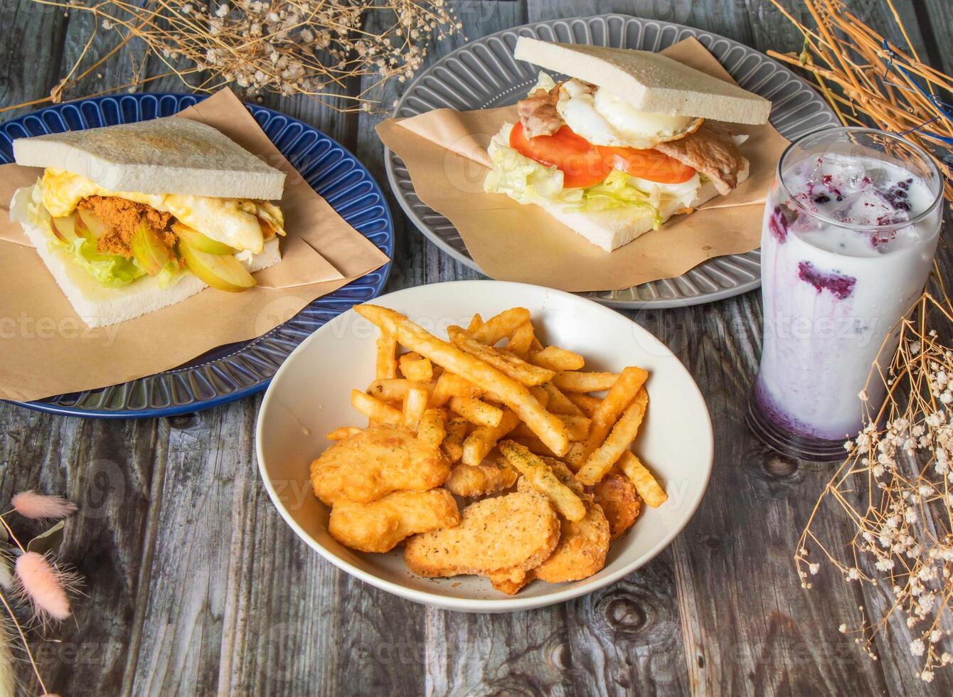 Crispy Chicken Nuggets and French Fries, Taiwanese Breakfast Sandwich, Apple pork floss egg toast, meat and egg toast, Iced Blueberry Latte served in plated side view of taiwan Brunch Platter photo
