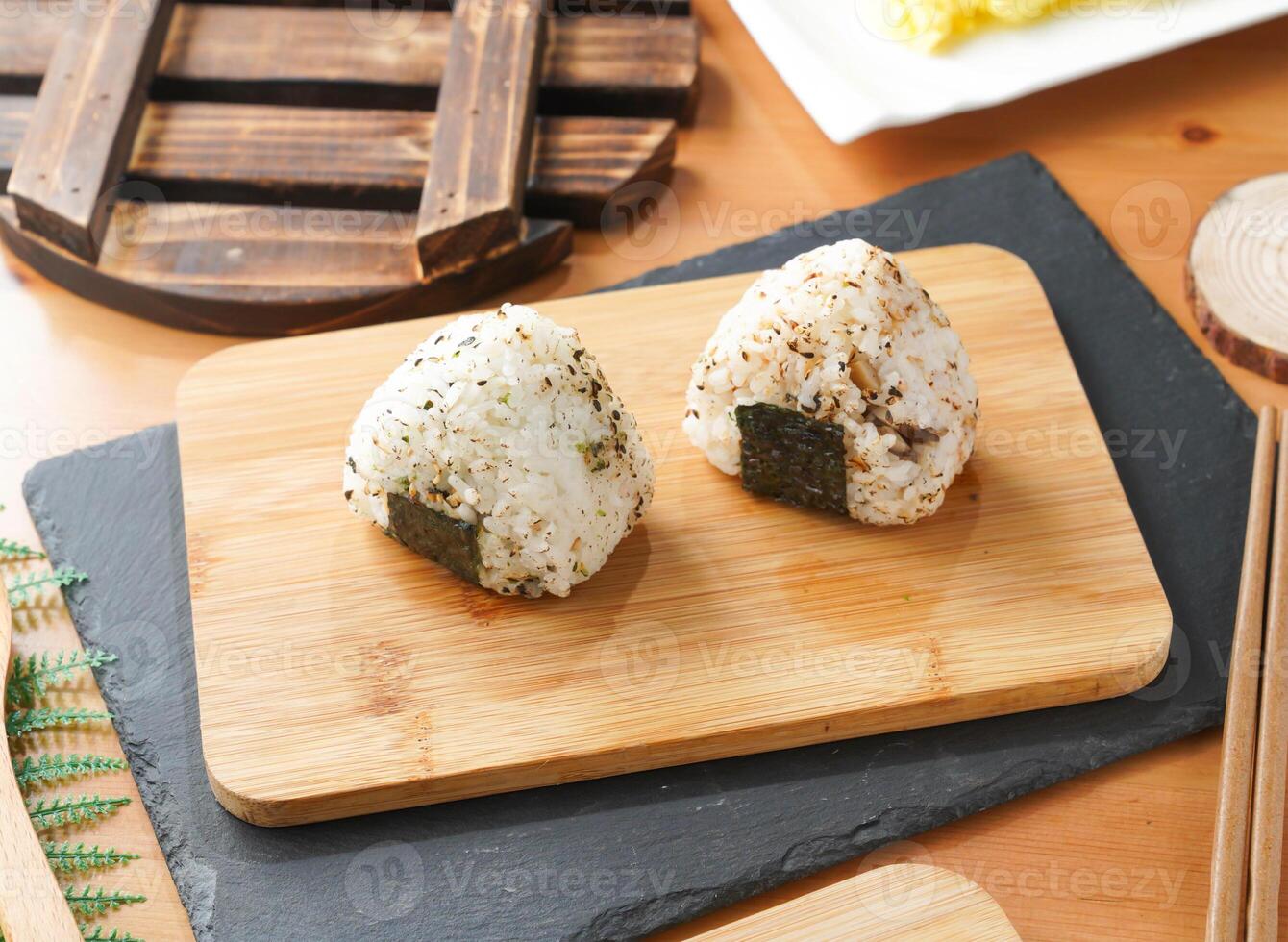 Grilled Rice Ball or Onigiri with Nori and Sesame Seeds served on wooden board with chopsticks side view of taiwan food photo
