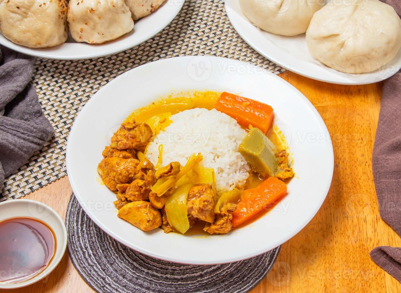 Nanyang Chicken Curry Rice and Steamed Buns with sauce served in plate isolated napkin side view of taiwan dim sum food photo