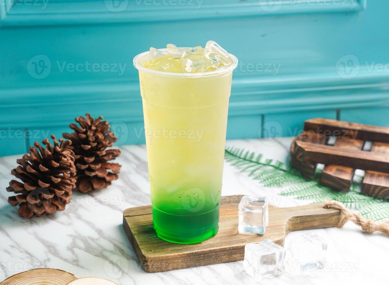 Iced Mint Green Tea with lime and ice cube in tall glass served on a wooden board side view of taiwan cold drink photo