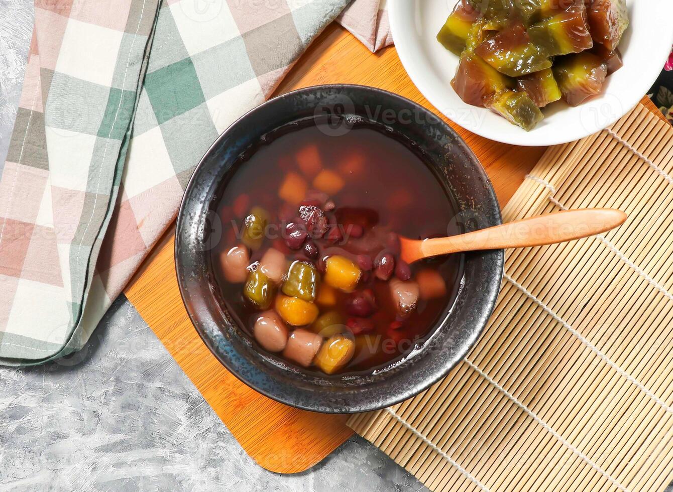 Taiwanese Mixed red bean soup include taro and sweet potato served in broth with spoon isolated on wooden board top view of traditional Asian dessert is perfect for a sweet treat taiwan photo