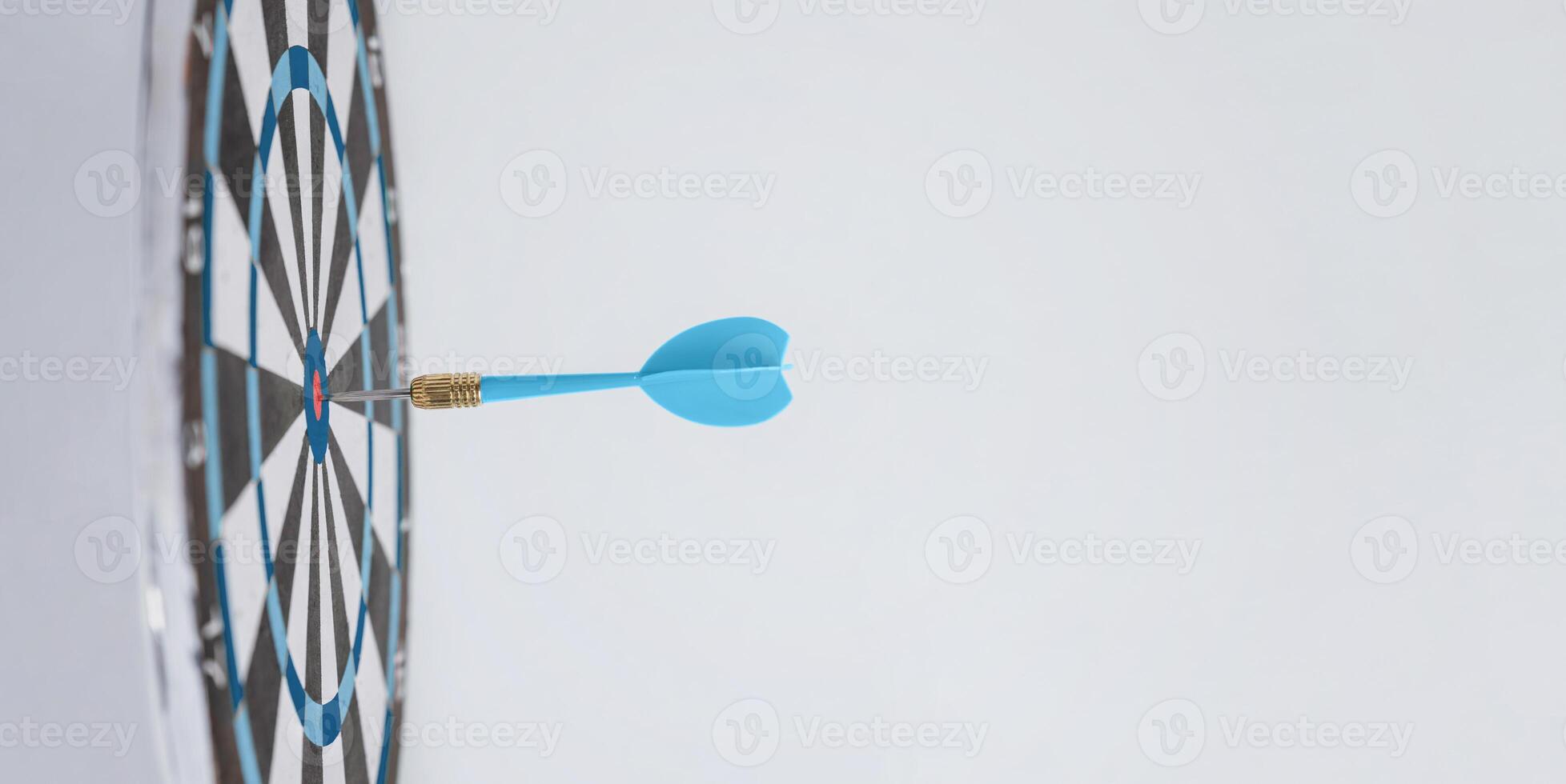 Blue dart embedded in the center of a target, symbolizing success, precision, and making the right moves to achieve goals effectively photo