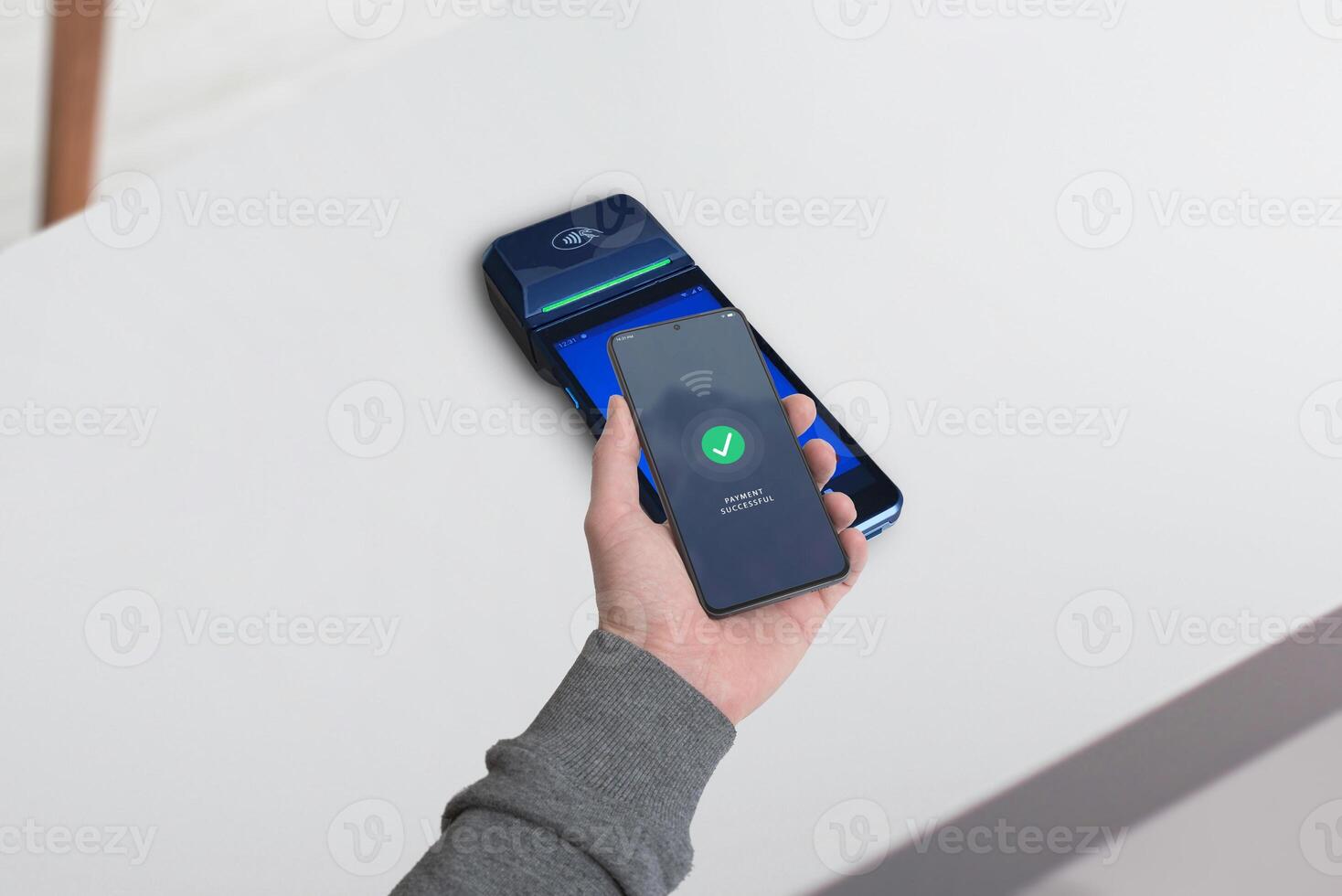 Smartphone completing a payment on a POS terminal with a wireless symbol and a Payment Successful message displayed, showcasing the concept of seamless mobile transactions photo