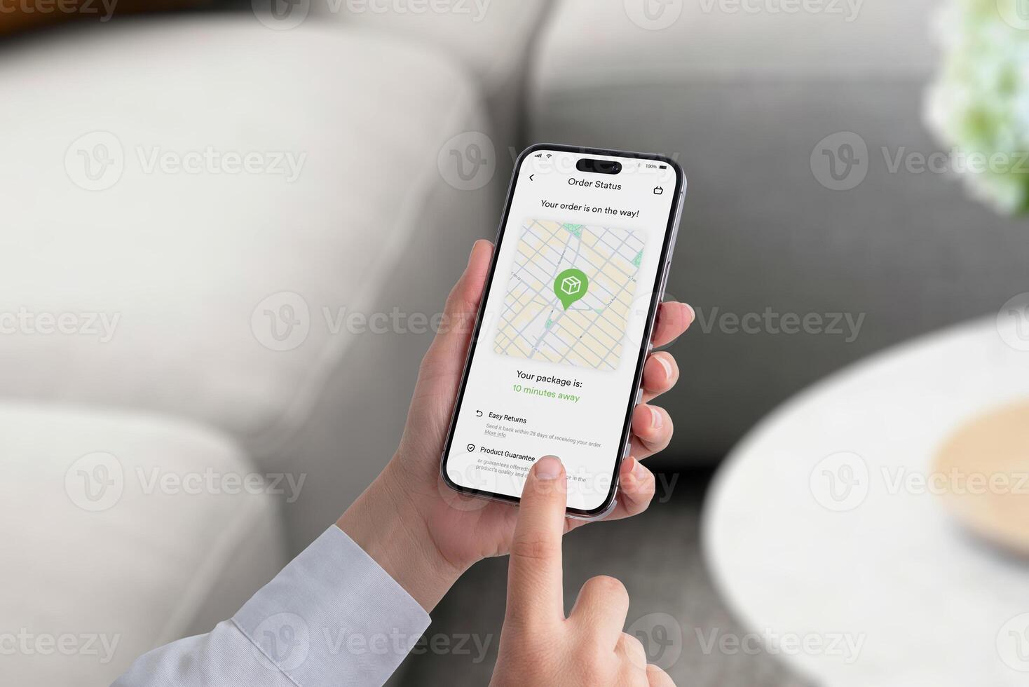 Smartphone screen displays an order tracking app with a map showing a package icon en route to delivery, estimated arrival 10 minutes photo