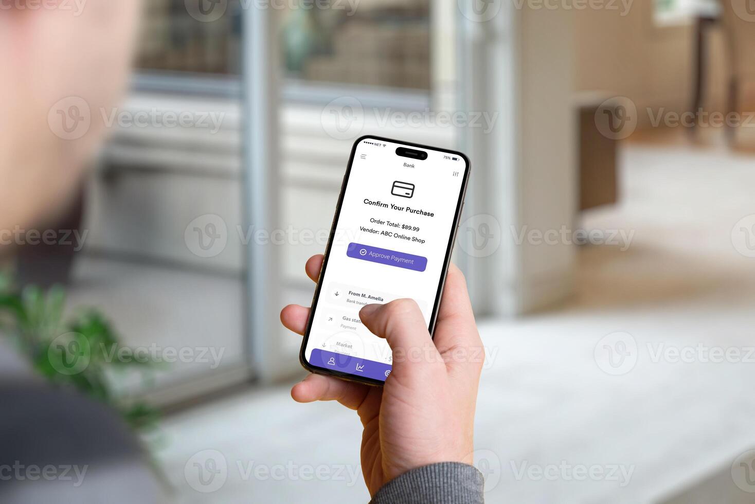 Man holding a smartphone with a banking app confirmation screen showing the purchase amount and an 'Approve Payment' button photo
