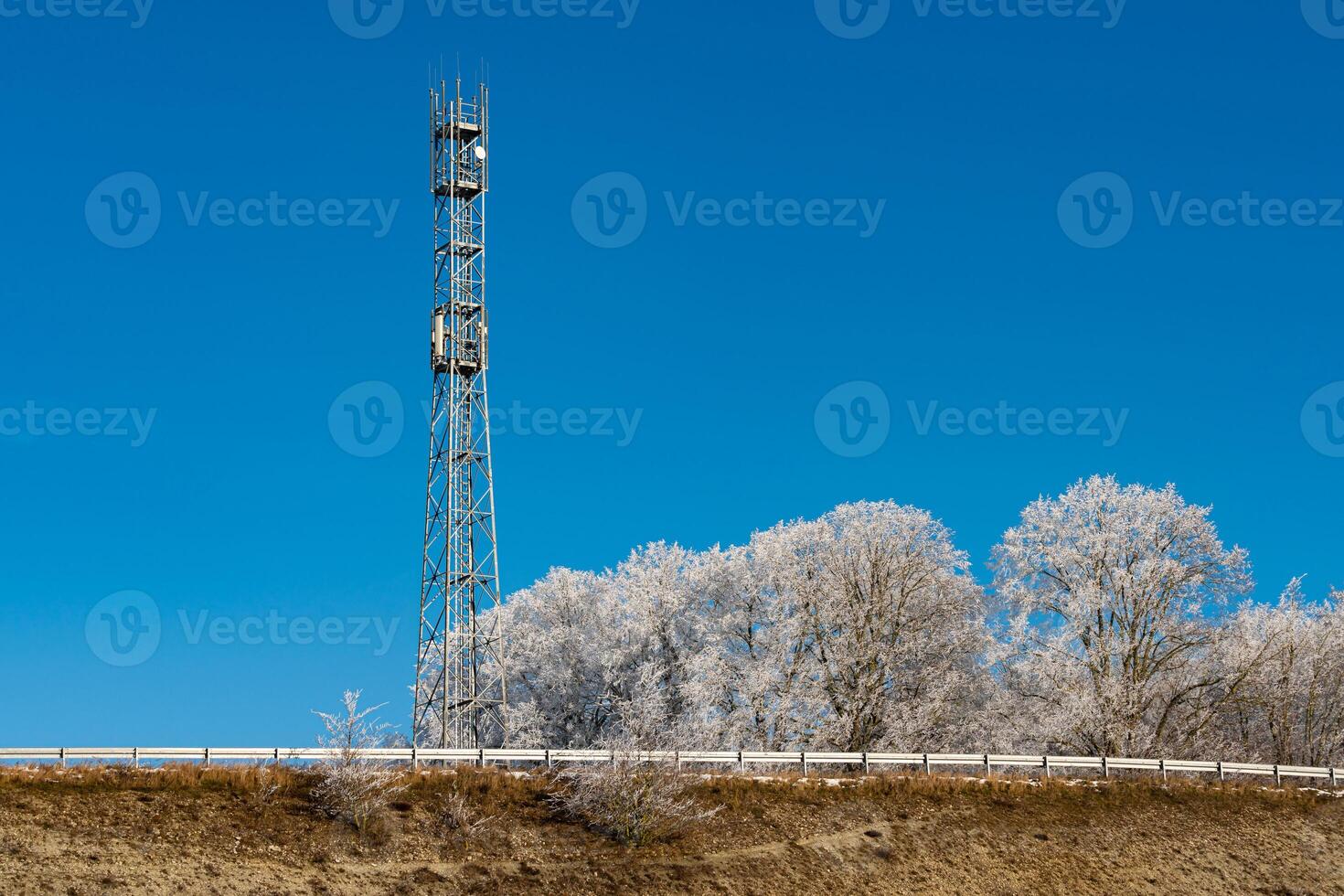 A communication tower rises prominently beside a frost-covered photo