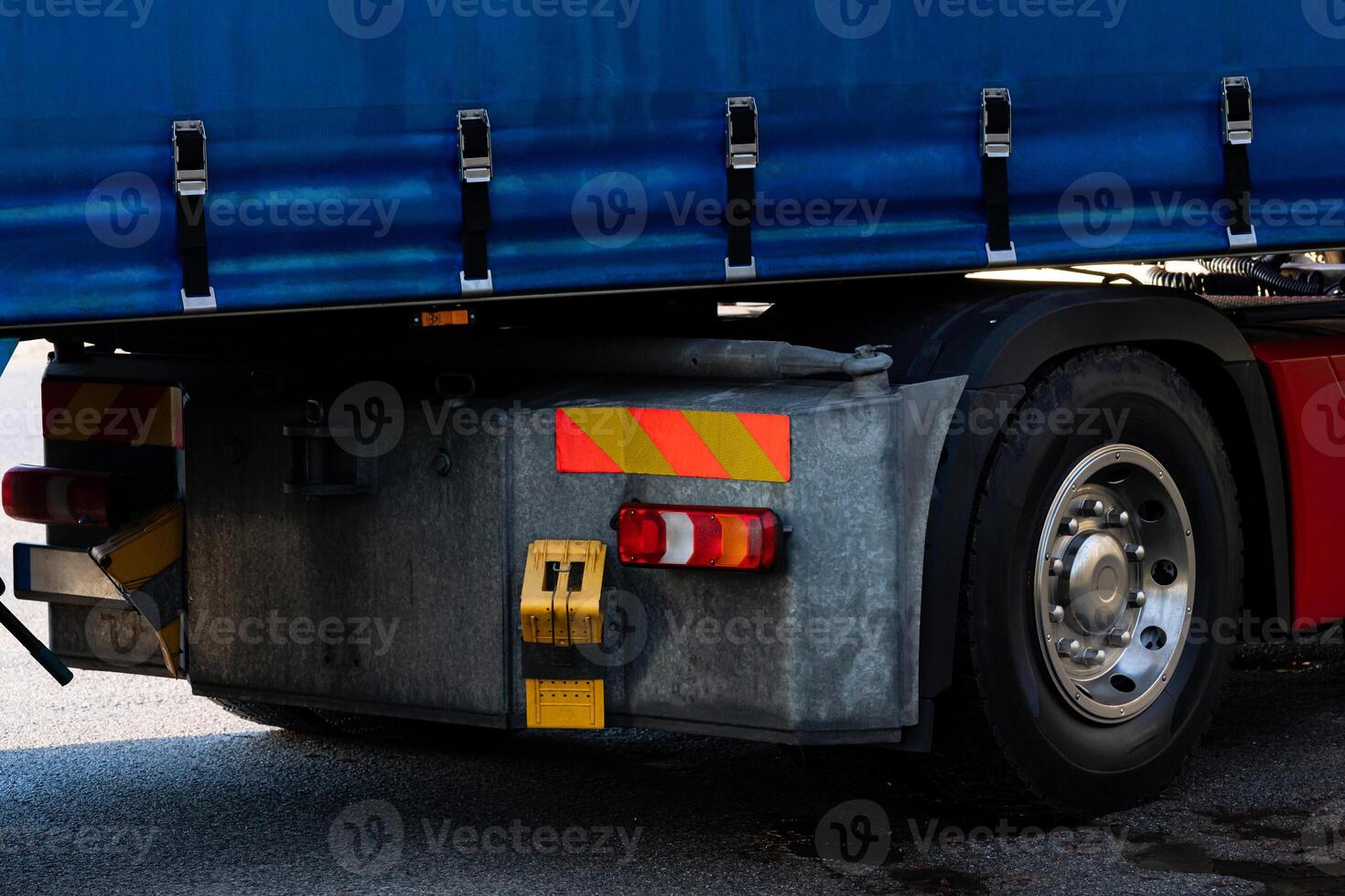Rear view of wheel and brake light of large truck parked at a loading photo