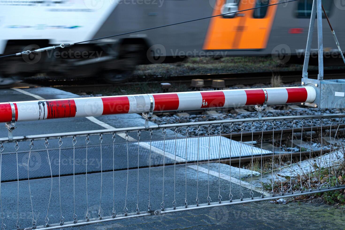 Train crossing barrier in action on urban railway tracks photo