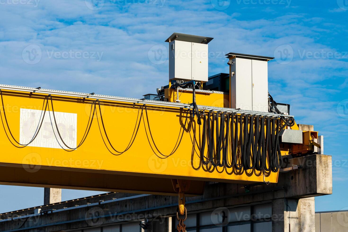 Heavy yellow overhead crane equipment working on a sunny day photo