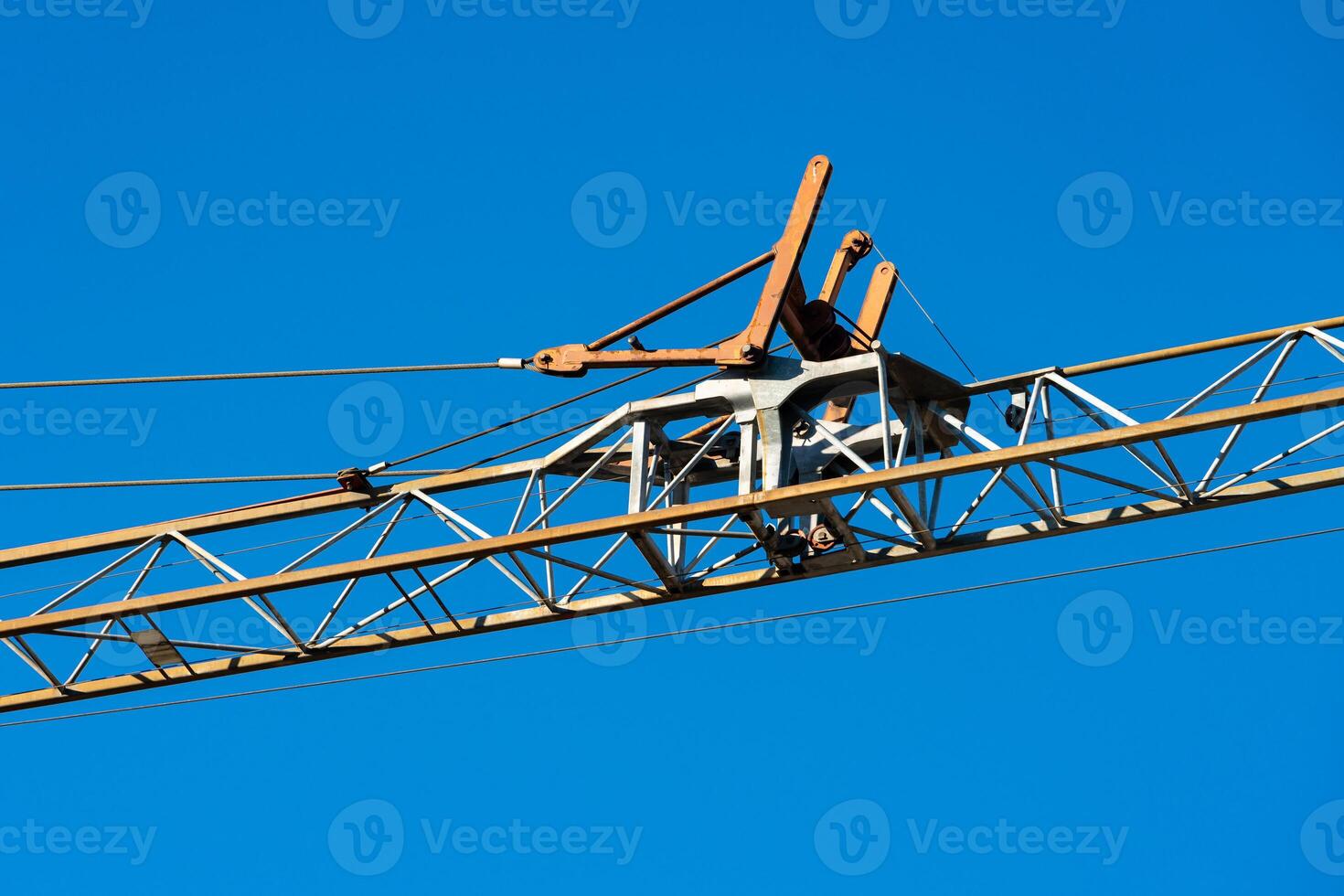 Crane structure against clear blue sky with minimal clouds photo