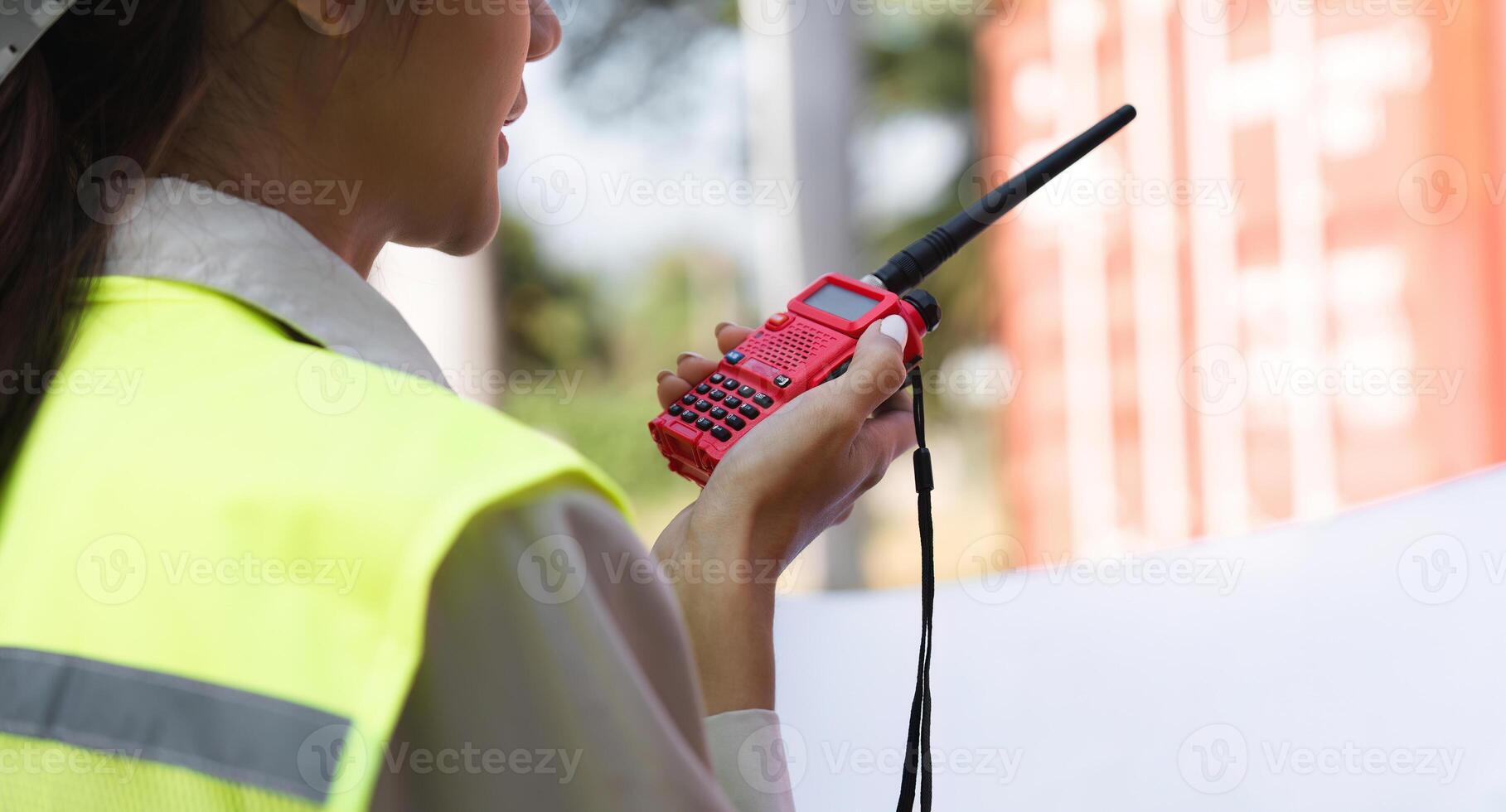 Close-up of a construction supervisor using a walkie-talkie for communication at a project site photo