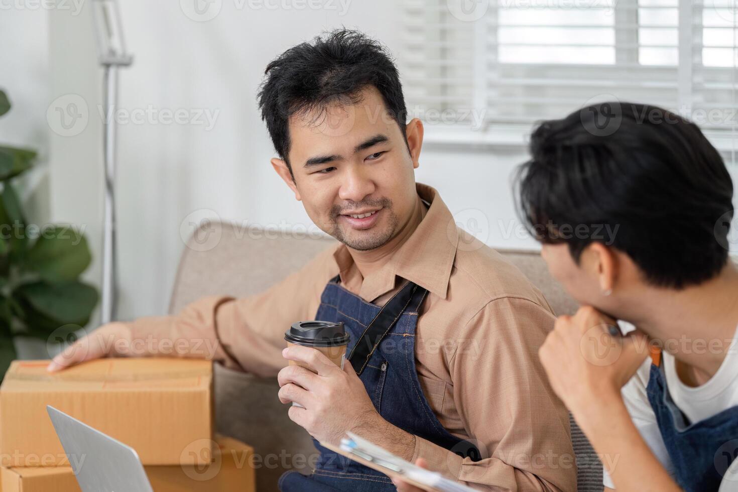 Young delivery professional sharing ideas while holding coffee and discussing strategies with a coworker photo