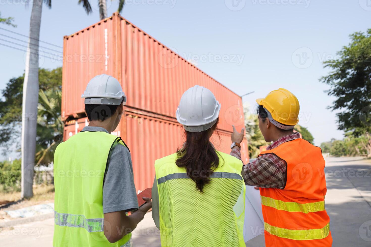 Construction team evaluating the project site and discussing plans with blueprints at a construction area photo