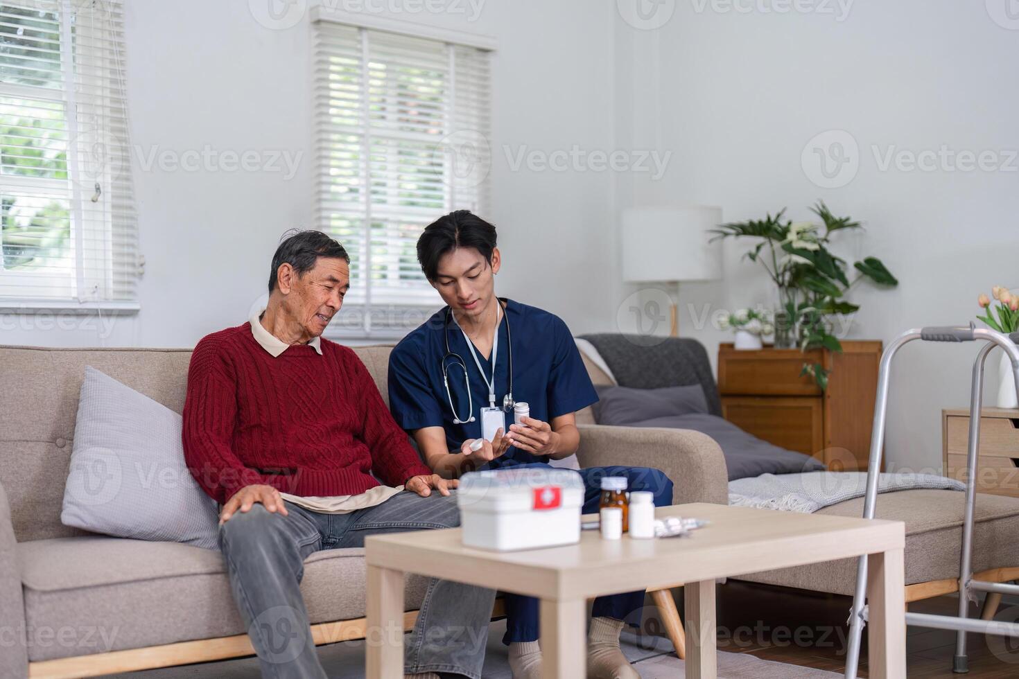 Nurse explaining medication to elderly patient during home visit in cozy living room photo