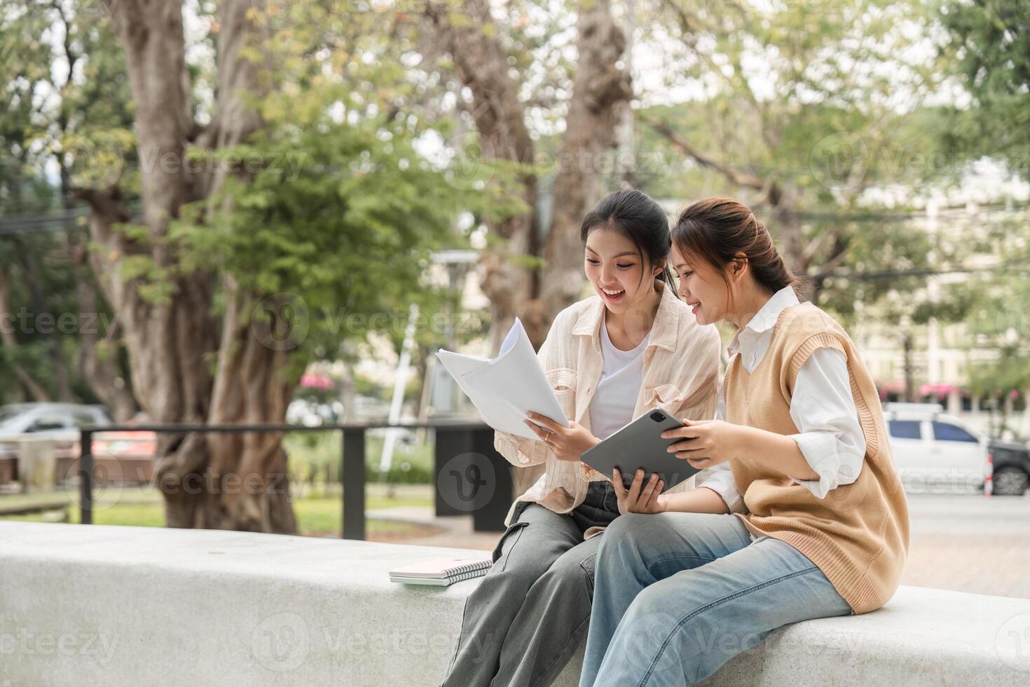Diverse students reviewing study materials together outdoors in a university setting. photo