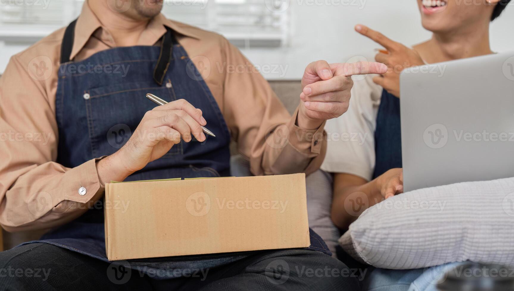 Delivery professionals playfully pointing while discussing packages in a cheerful workspace photo