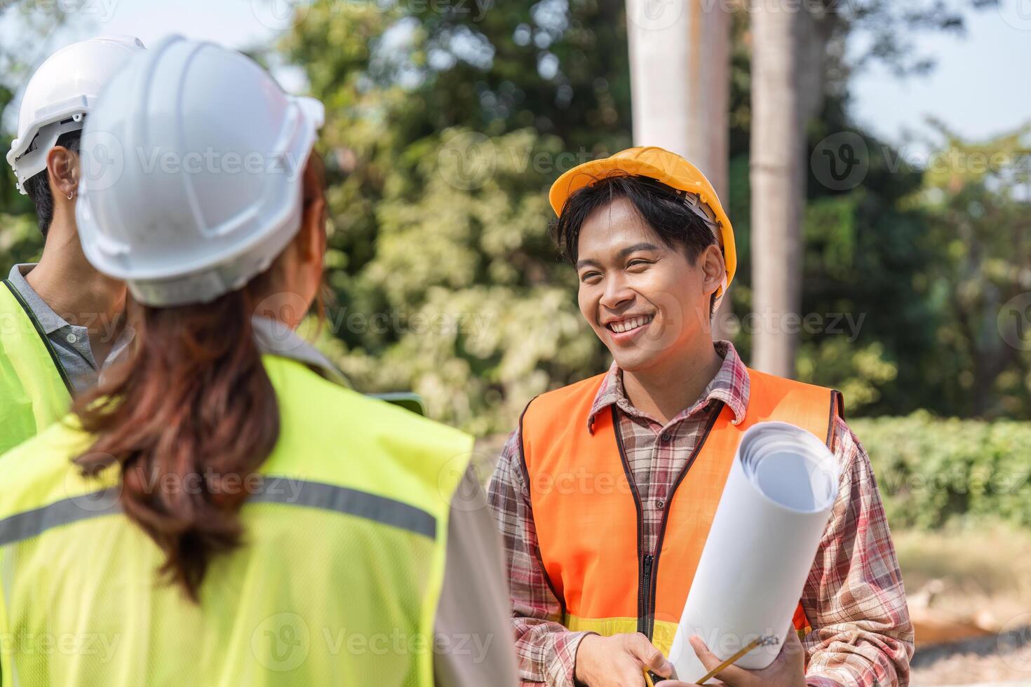 Logistics engineering team celebrating project milestones and discussing blueprints on a sunny construction site photo