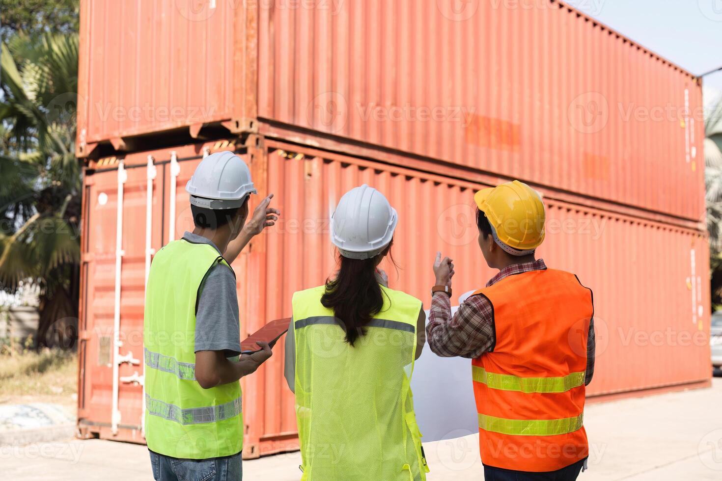 Construction team discussing logistics and planning strategies at a site with shipping containers photo