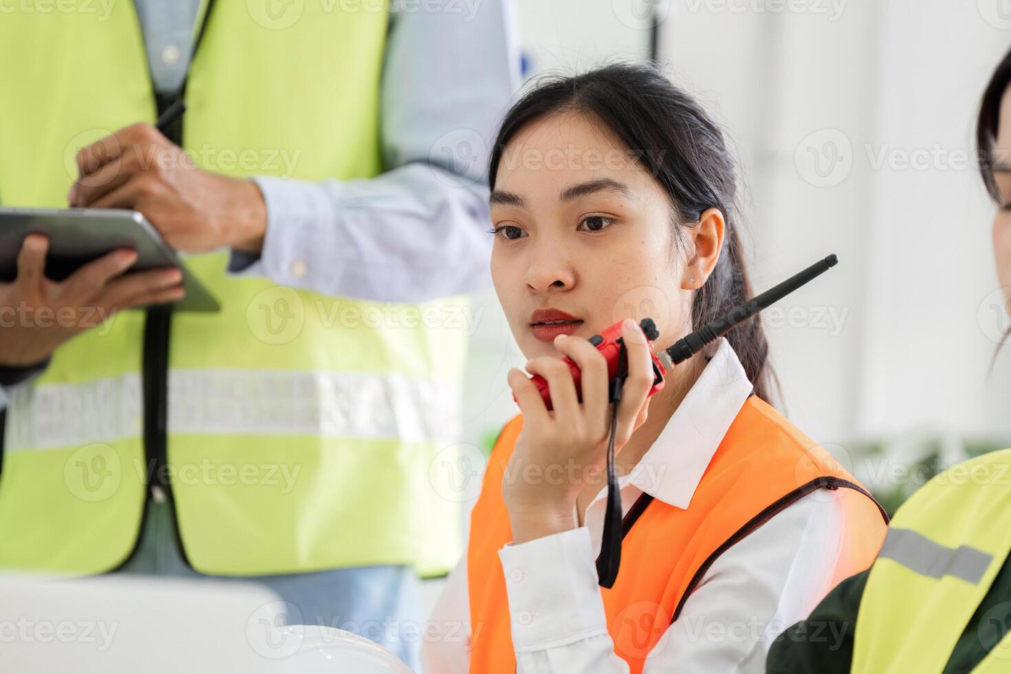 Construction supervisor communicating with team using a walkie-talkie during a project meeting photo