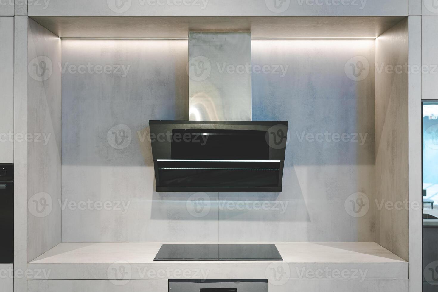 Elegant kitchen interior with modern range hood over Induction cooker. Interior of modern kitchen with induction hob. photo
