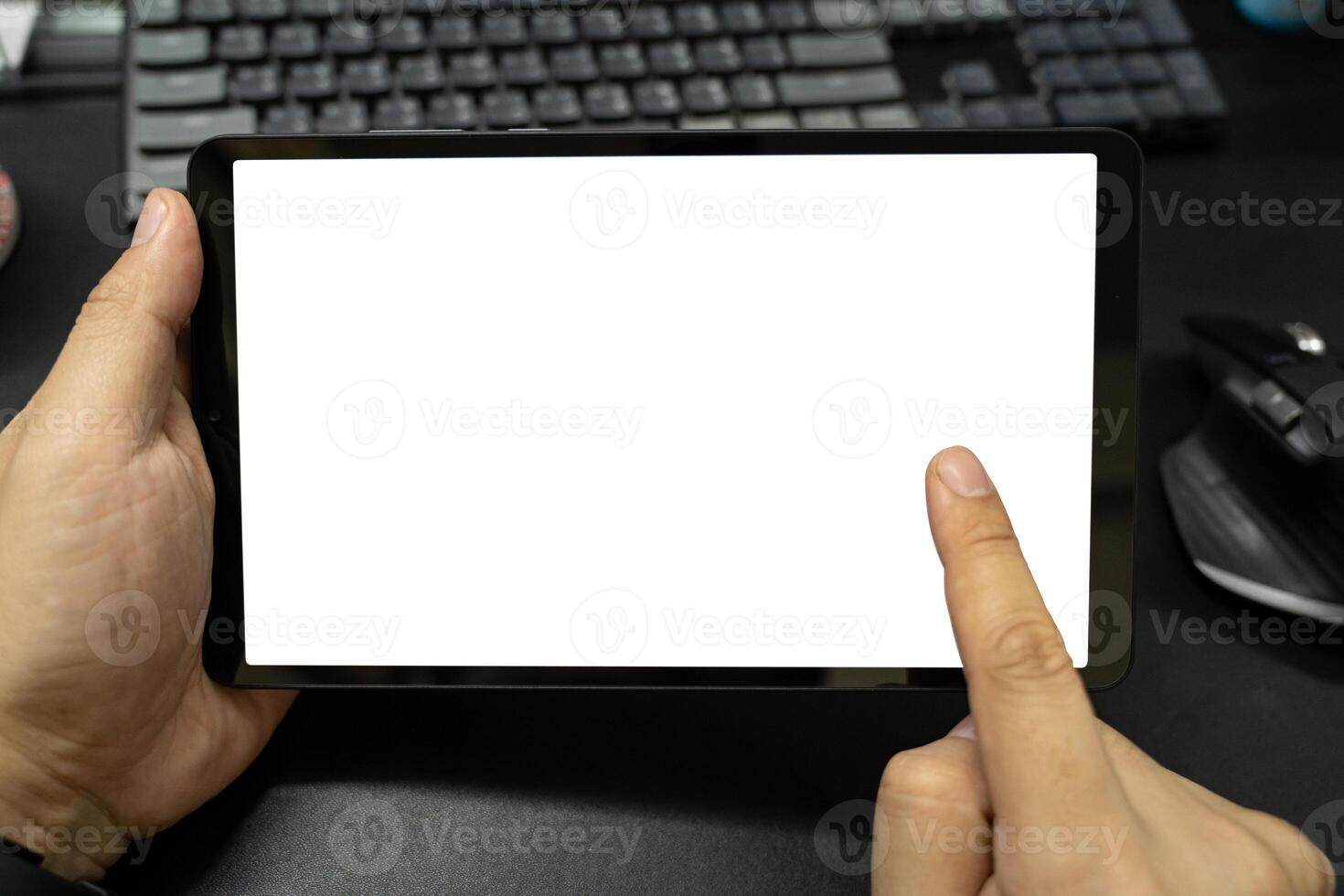 Blank screen tablet on desk. Digital tablet with isolated screen in male hands. photo