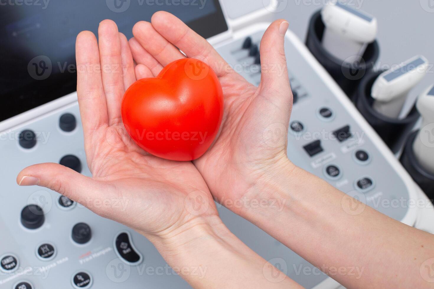 doctor holding heart near ultrasound scanning diagnostic equipment photo