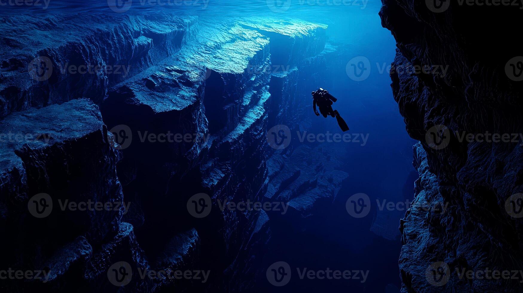 a scuba diver at the edge of a drop-off, endless deep blue abyss, feeling of awe and solitude. photo