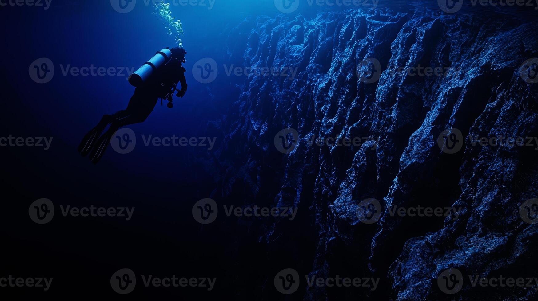 scuba diver at the edge of a drop-off, endless deep blue abyss, feeling of awe and solitude.,, photo