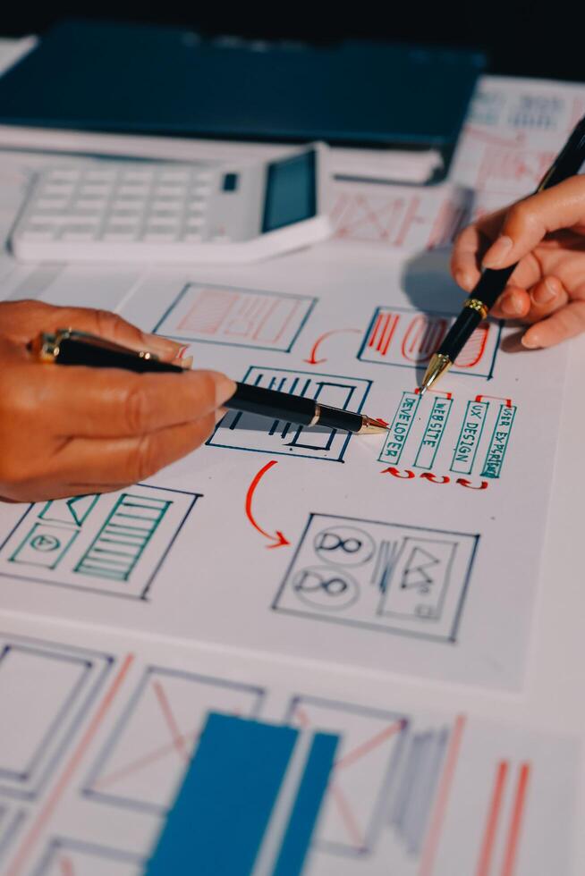 Two people working on a project with a pen and paper photo