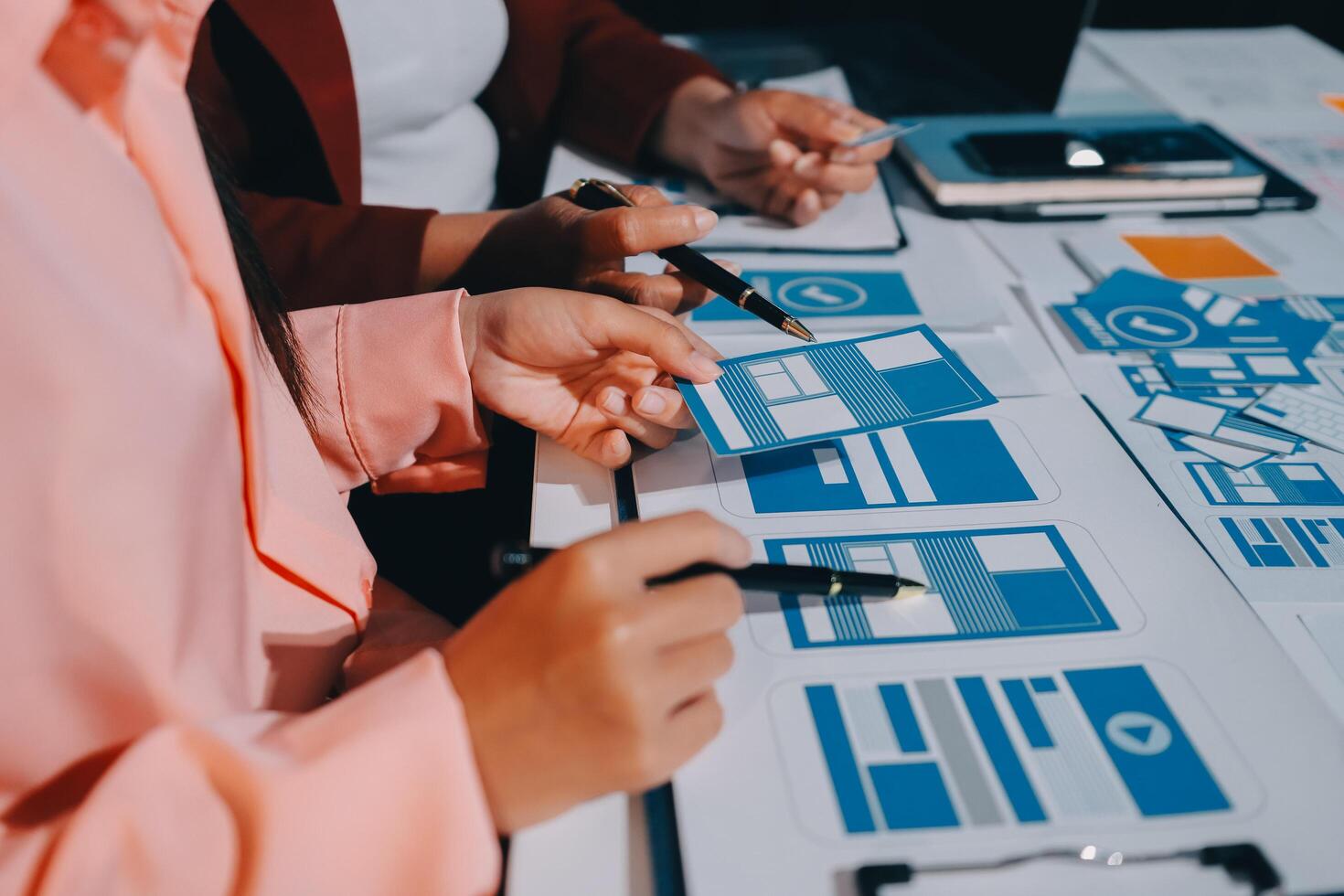 A group of people working on a project with blue and white paper photo