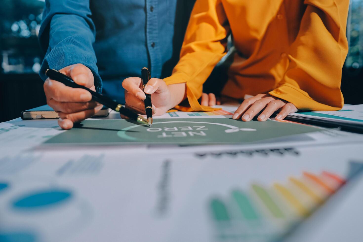 Business people working on a project with graphs and papers photo