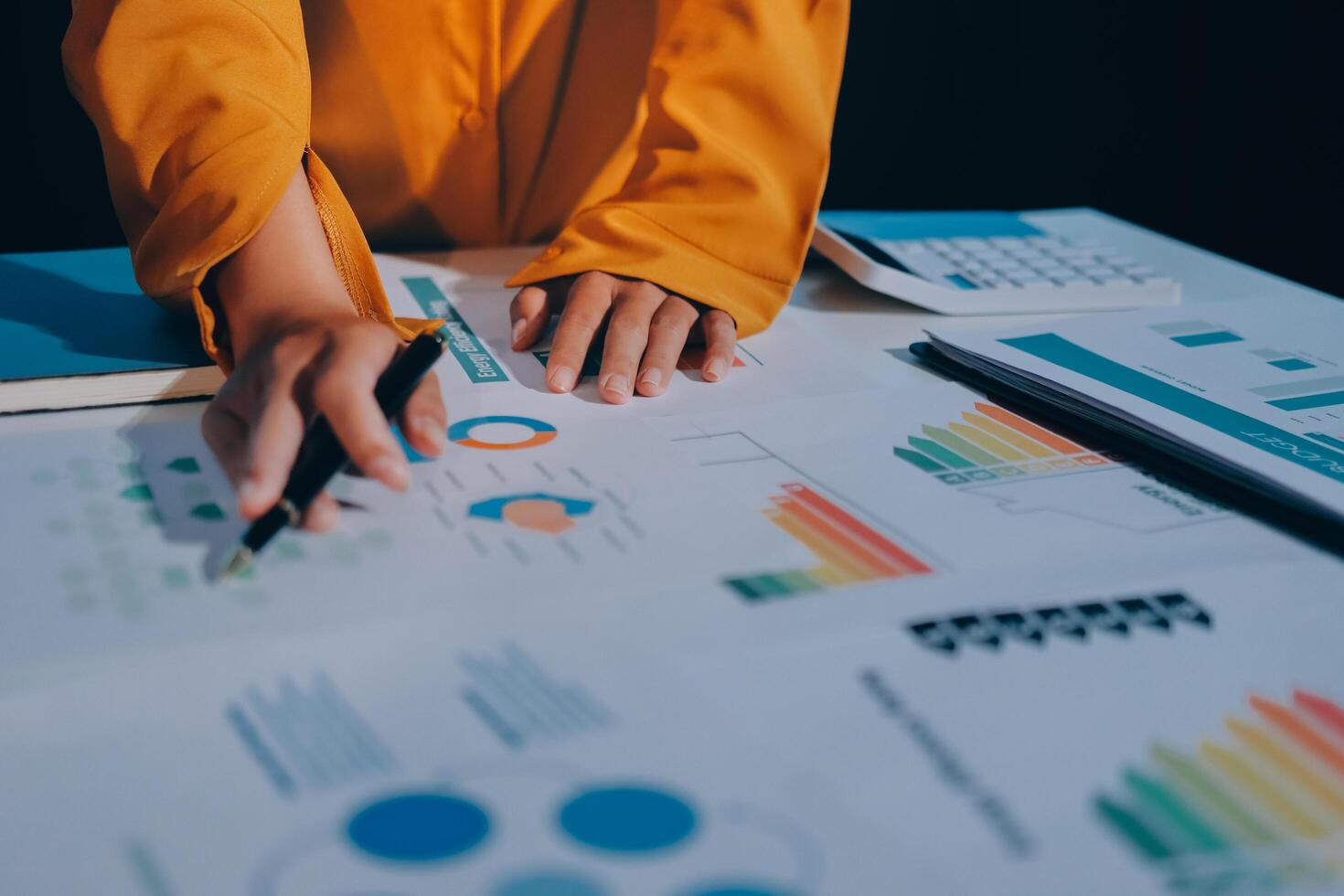 A person is working on a business plan with graphs and papers photo