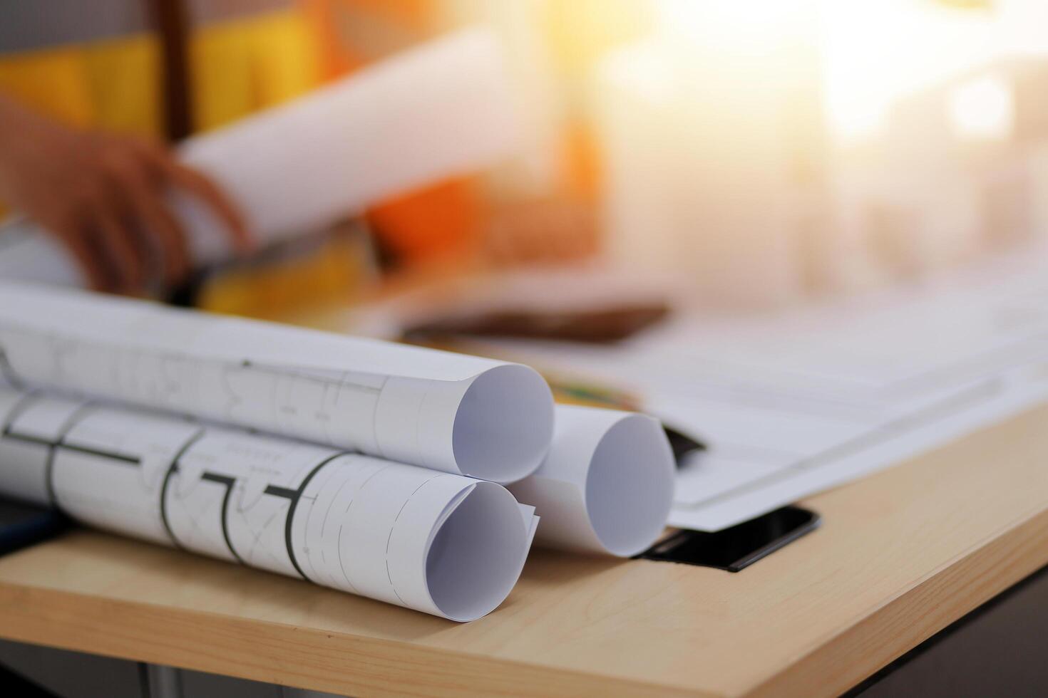 A man is working on a table with blueprints photo