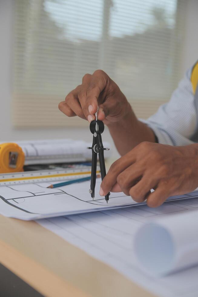 A person is holding a pair of scissors while working on a piece of paper photo